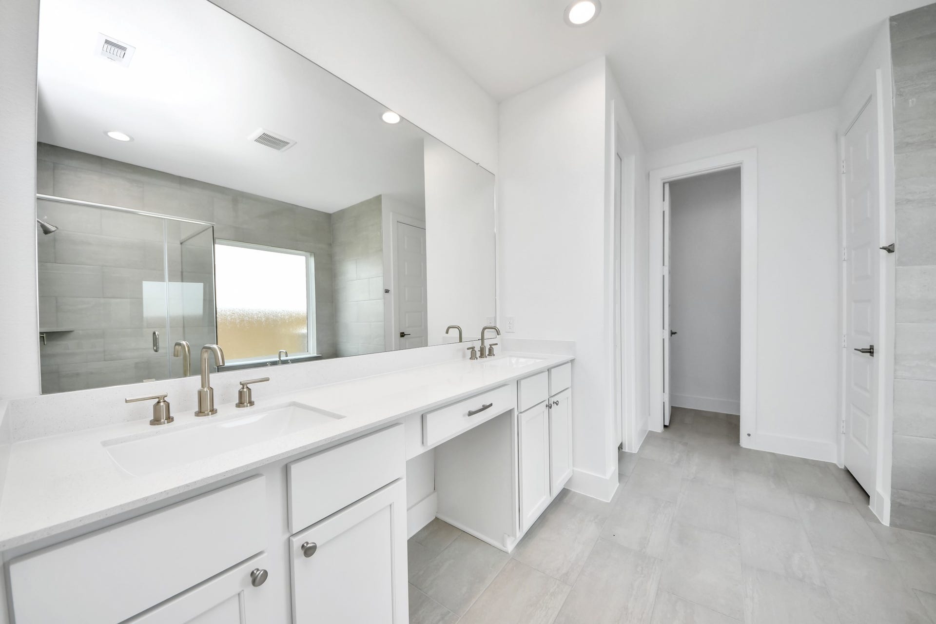 5906 Fox Peak Lane, Richmond, TX 77469 Escape to a spa-like oasis in this primary bathroom. Enjoy a walk-in shower with tile surround, a separate garden tub with custom detailing, and an elegant vanity featuring light countertops, modern hardware, and beautiful recessed lights. Experience luxury and relaxation in every detail. Sample photo of completed home with similar floor plan. Actual colors and selections may vary.