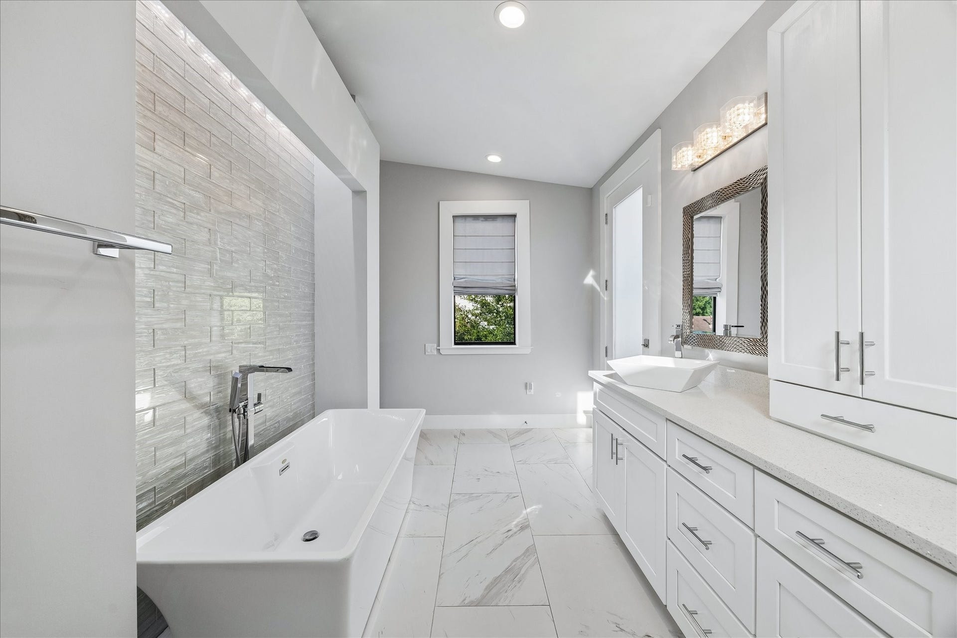 1959 Portsmouth Street, Houston, TX 77098 Deep soaking tub and separate walkin shower with glass door. Stunning
tile backsplash along the bathtub is
an incredible feature!