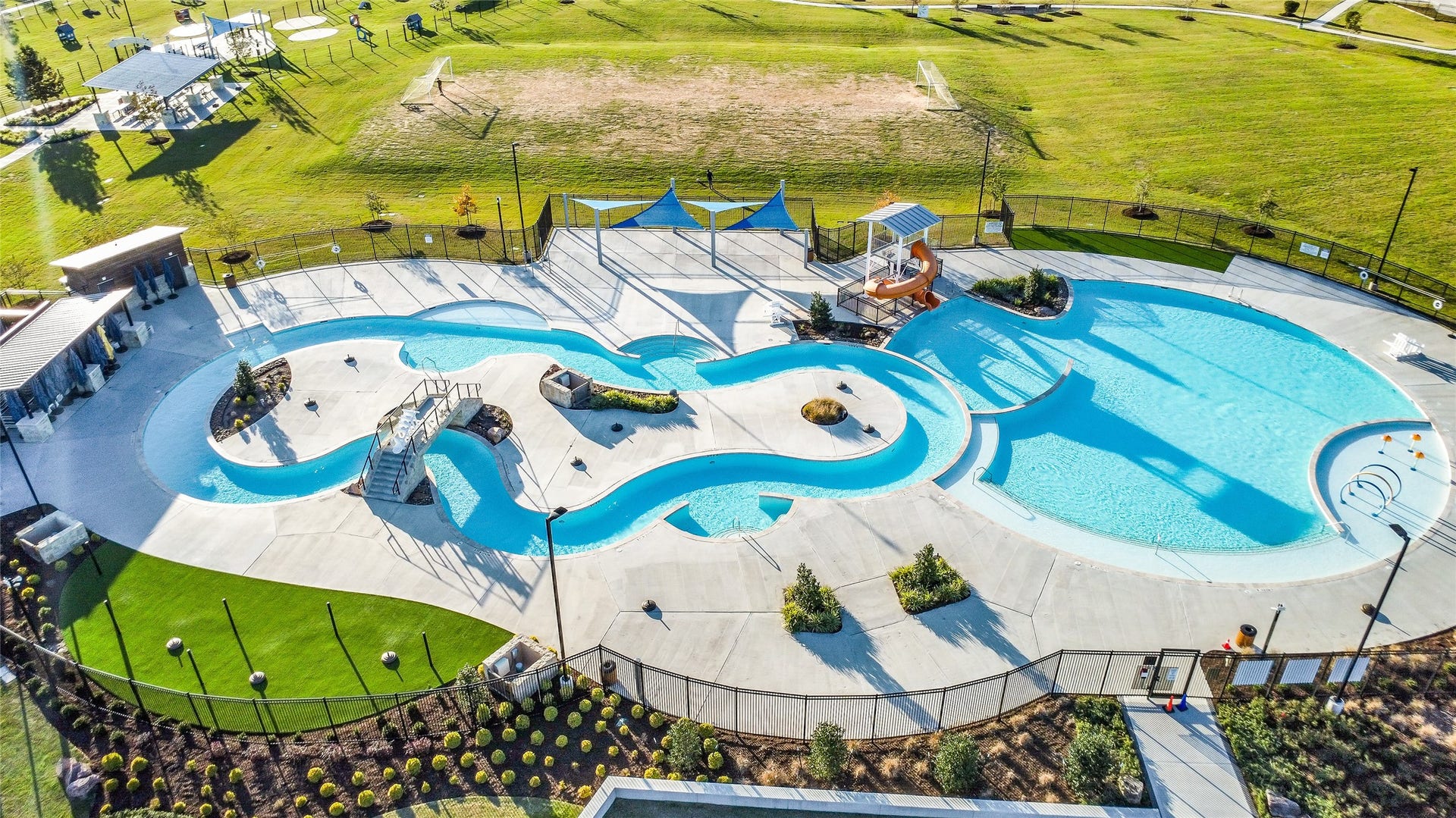 A broad aerial view showcasing
the thoughtfully planned layout of
lakes, buildings, and recreational
spaces such as the corner park
playground