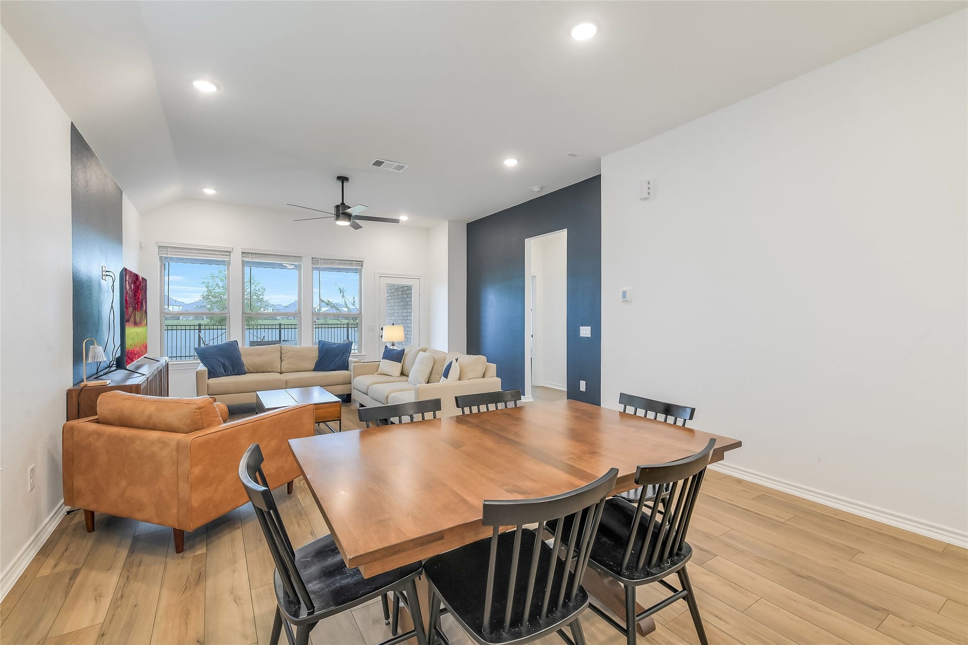 Dinner comes with a view. This spacious dining area enjoys sightlines toward the lake while connecting seamlessly to the kitchen and living roomideal for everything from casual mornings to memorable dinner parties.
