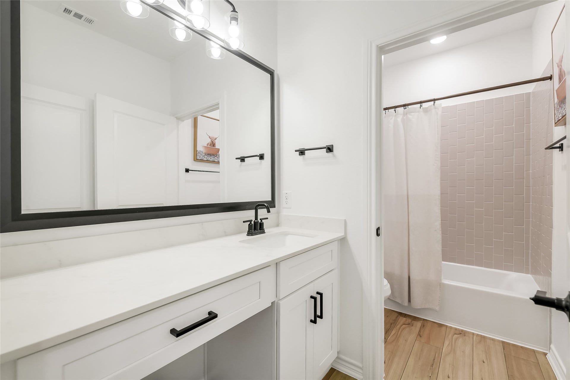 Fresh, polished secondary bath offers a bright and functional space for family or guests, continuing the homes clean, contemporary design throughout.