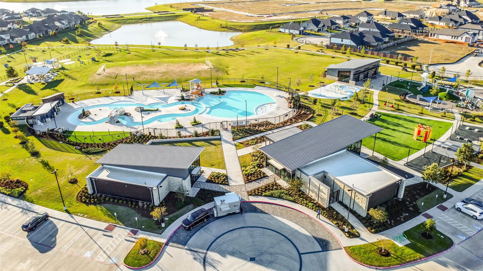 A broad aerial view showcasing
the thoughtfully planned layout of
lakes, buildings, and recreational
spaces such as the corner park
playground