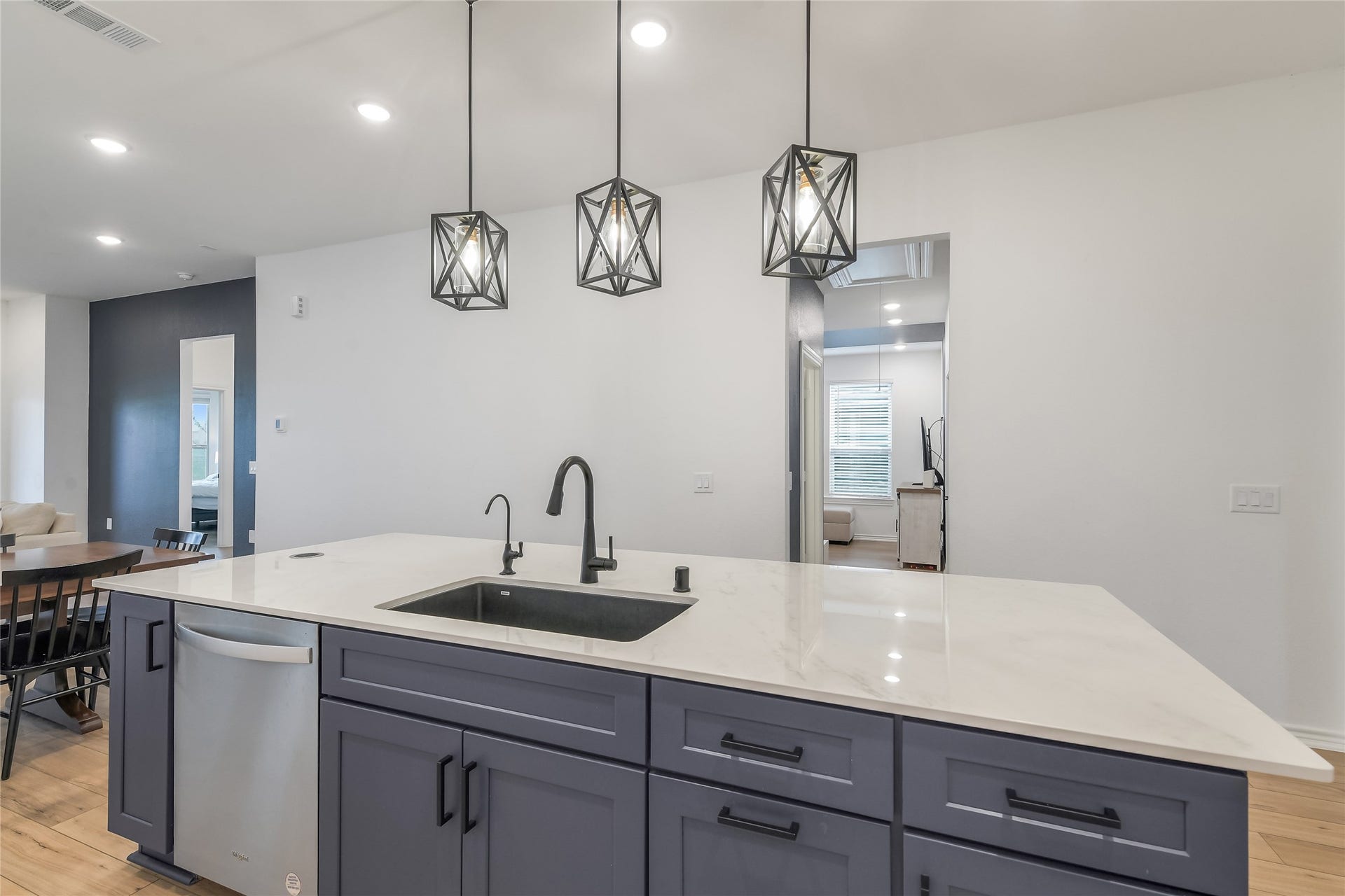 Expansive quartz island with undermount sink, modern fixtures, abundant storage, and generous workspace creates a functional centerpiece for cooking, serving, and entertaining. Reverse Osmosis under sink