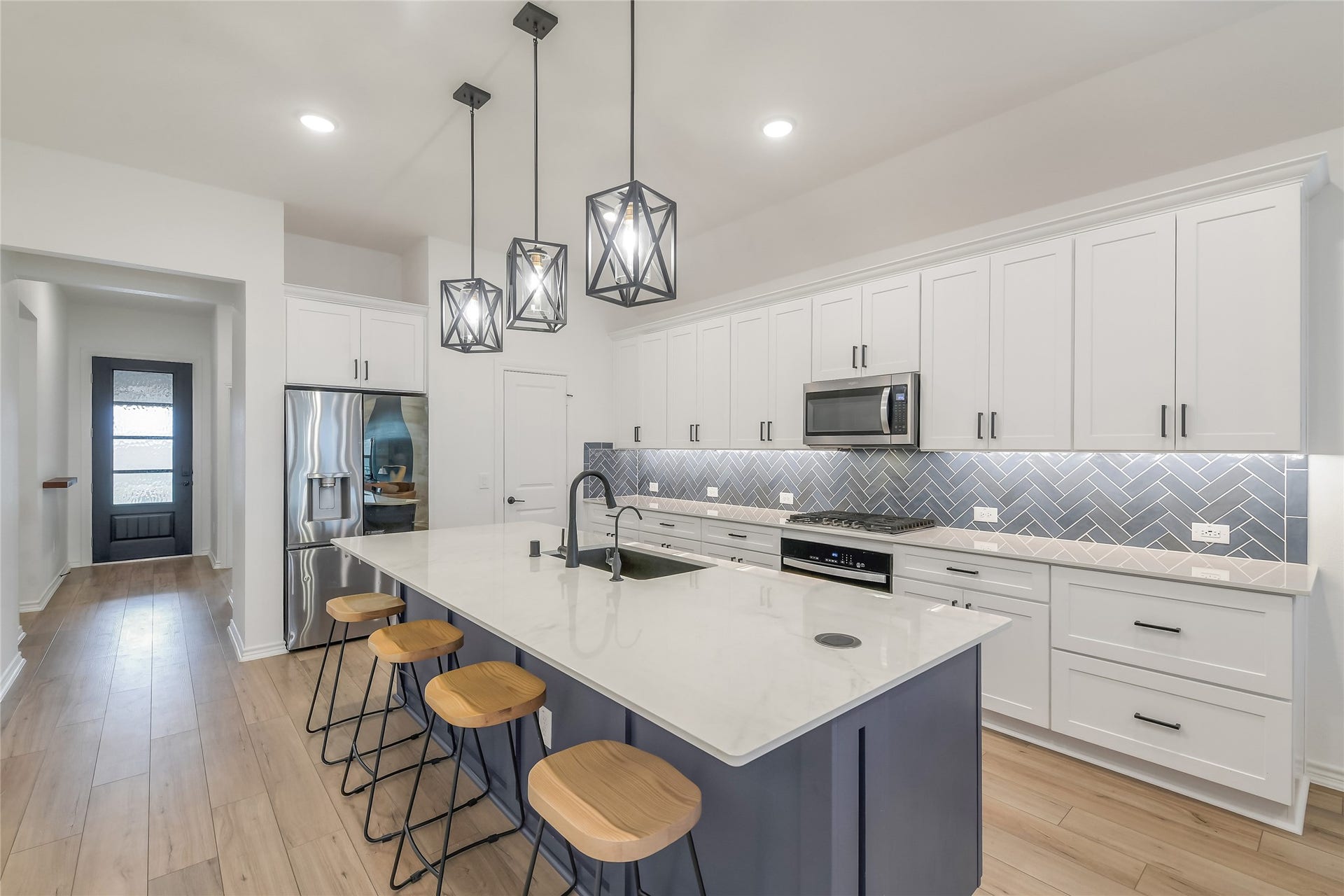 The impressive oversized island anchors the kitchen with quartz countertops, bar seating, additional storage, and generous prep spaceperfect for casual meals, entertaining, and gathering with guests.