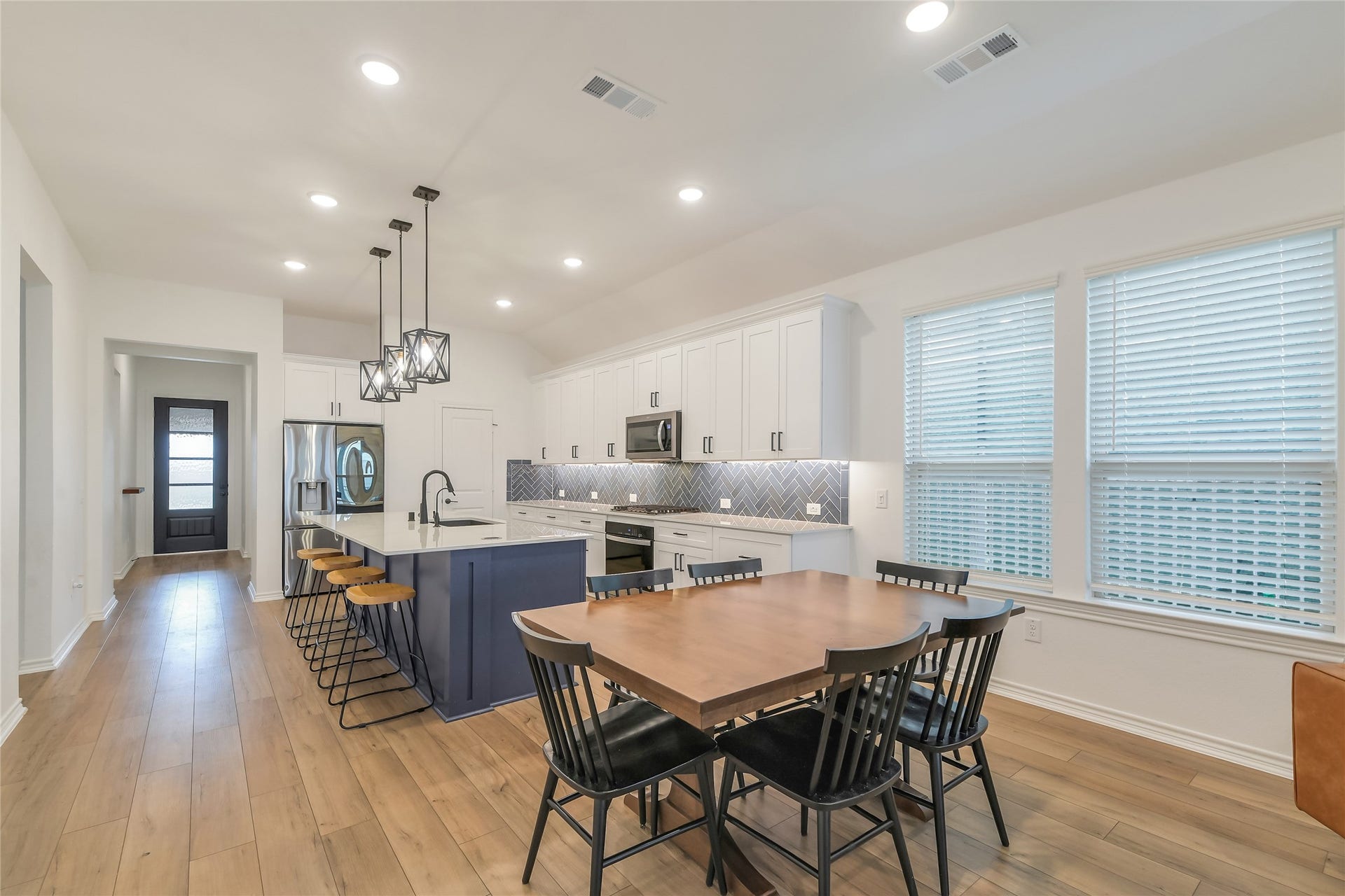 Designed for entertaining, the open kitchen and dining area offers an effortless flow with an oversized island, generous cabinetry, abundant counter space, and windows bringing natural light into the heart of the home.