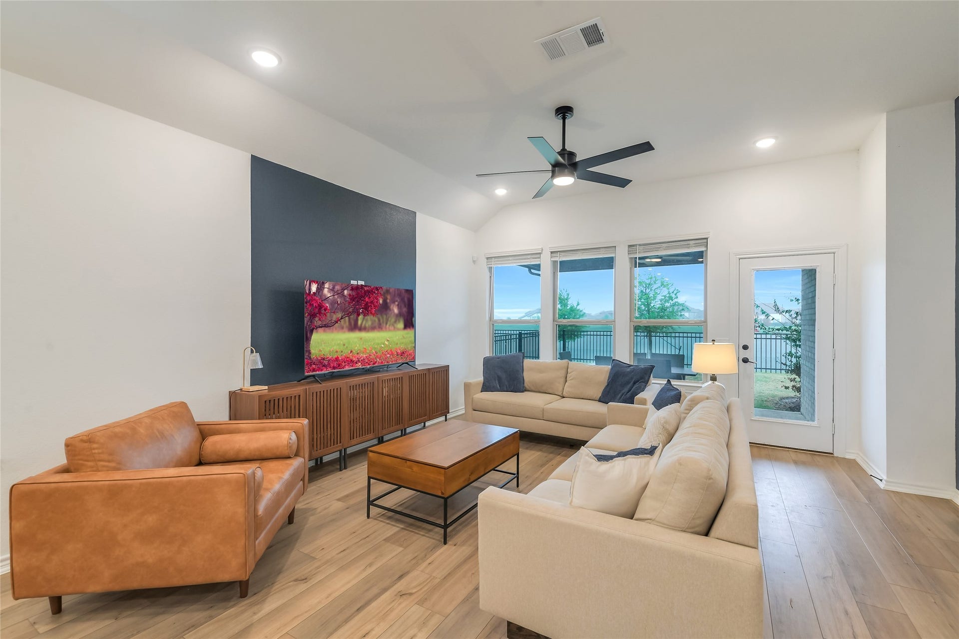 Imagine relaxing or entertaining with the lake as your backdrop. This spacious open-concept living area features high ceilings, abundant natural light, modern finishes, and direct views toward the water.