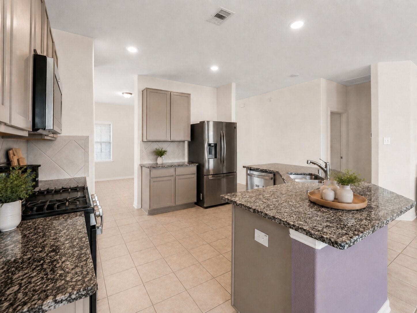 1503 Barras Street, Alvin, TX 77511 *virtually staged* The kitchen features granite countertops, abundant cabinetry, stainless steel appliances, and a spacious center island.