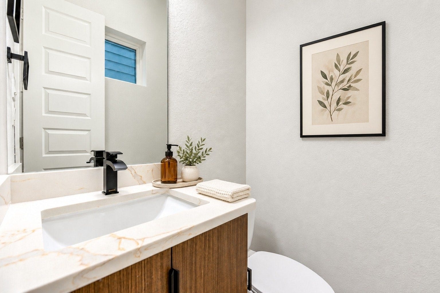 Second floor half bath featuring modern single vanity with quartz counters, sleek matte black hardware.