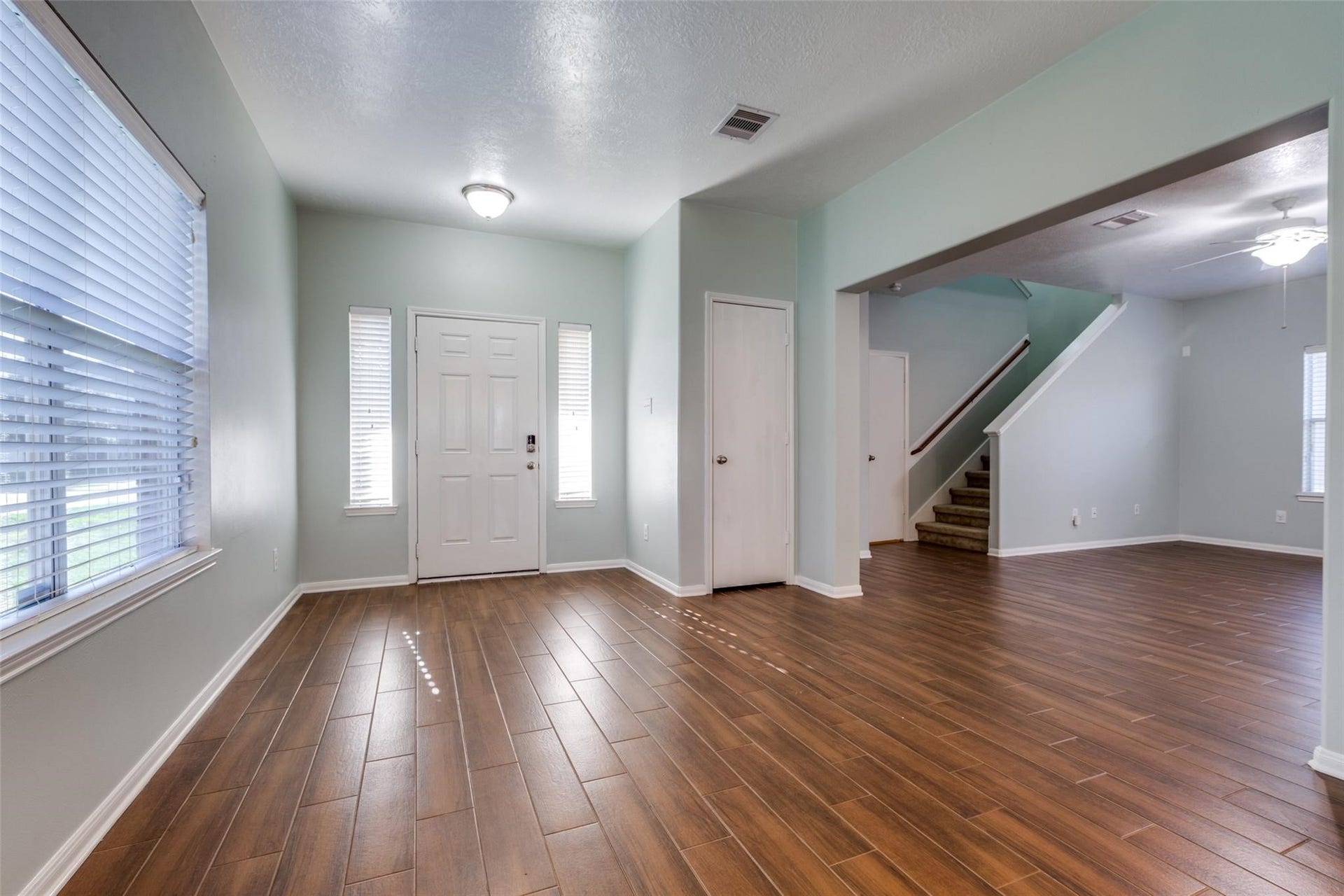 Step into a welcoming entry foyer featuring beautiful wood-look tile flooring that flows seamlessly throughout the entire first floor, offering both style and durability. Just beyond the entry, youll find the inviting living room, ready to welcome family and friends.