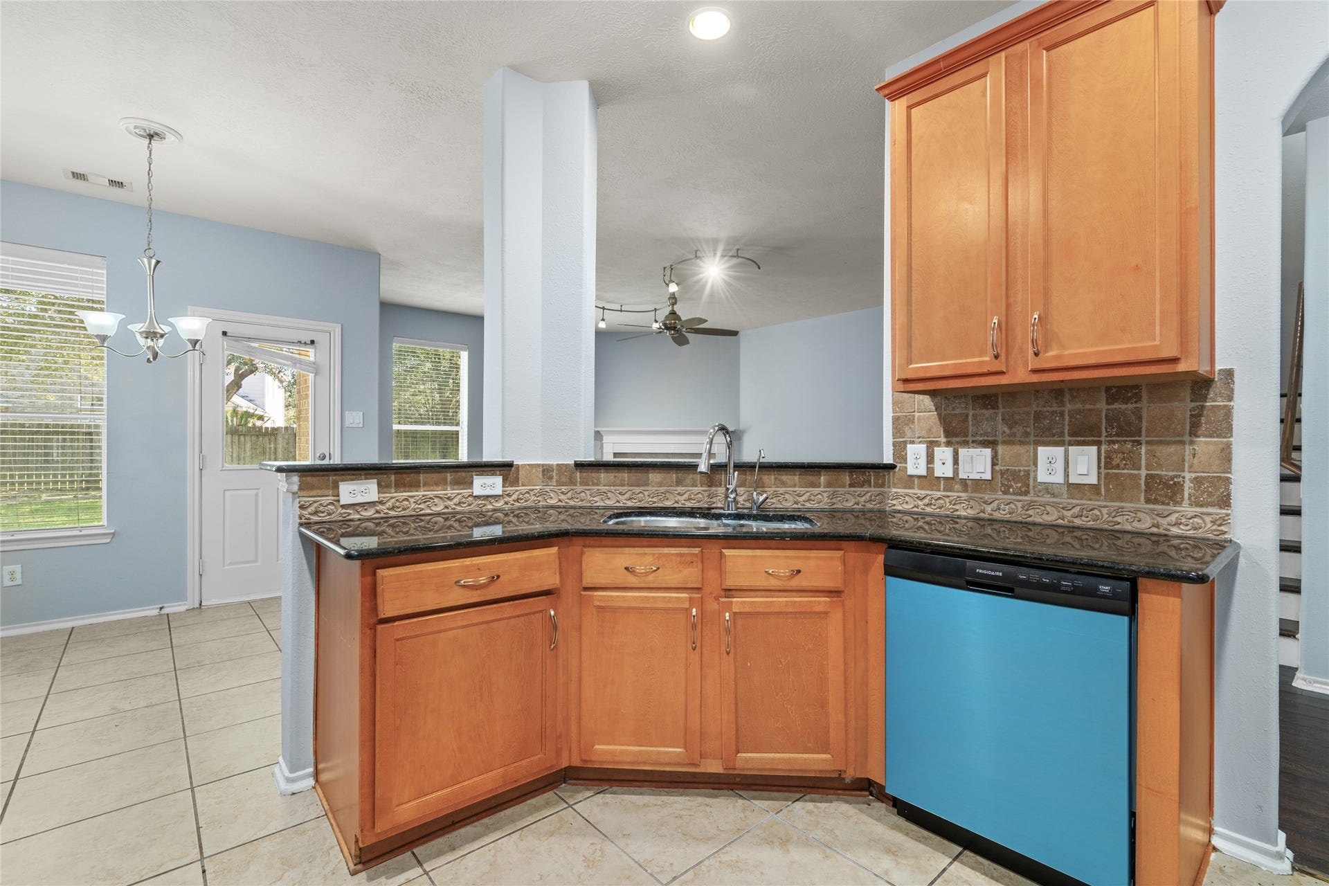 24519 Evangeline Springs Lane, Katy, TX 77494 Kitchen corner featuring wraparound granite countertops, wood cabinetry, and a broad work surface. The layout provides room for meal preparation while maintaining an open connection to the surrounding living and dining areas.