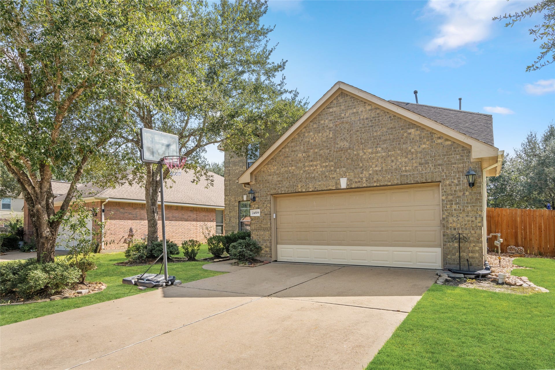 24519 Evangeline Springs Lane, Katy, TX 77494 Attractive brick exterior featuring a spacious two-car garage, extended driveway, and landscaped front yard. The driveway provides convenient off-street parking for residents and guests.