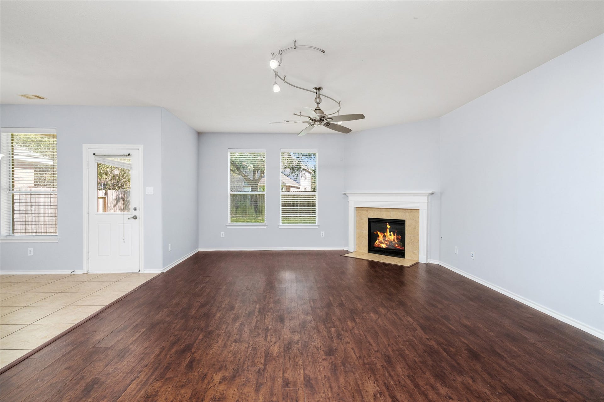 24519 Evangeline Springs Lane, Katy, TX 77494 Unfurnished living room highlighting its spacious footprint, wood flooring, fireplace, and natural light. Buyers can envision different furniture arrangements while enjoying a central gathering area with room to spread out.