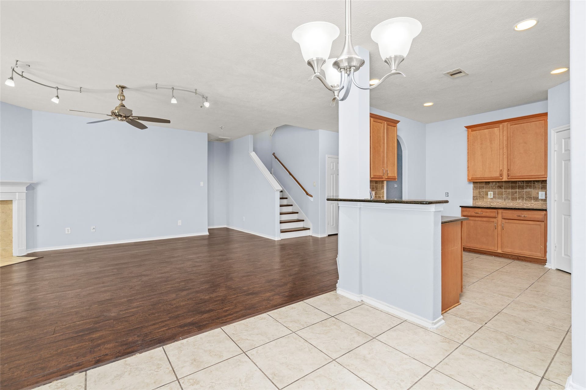 24519 Evangeline Springs Lane, Katy, TX 77494 Open view connecting the kitchen, breakfast area, and living room, with the staircase visible beyond. The connected layout gives the main floor a spacious feel and allows activities in different areas to remain visually connected.