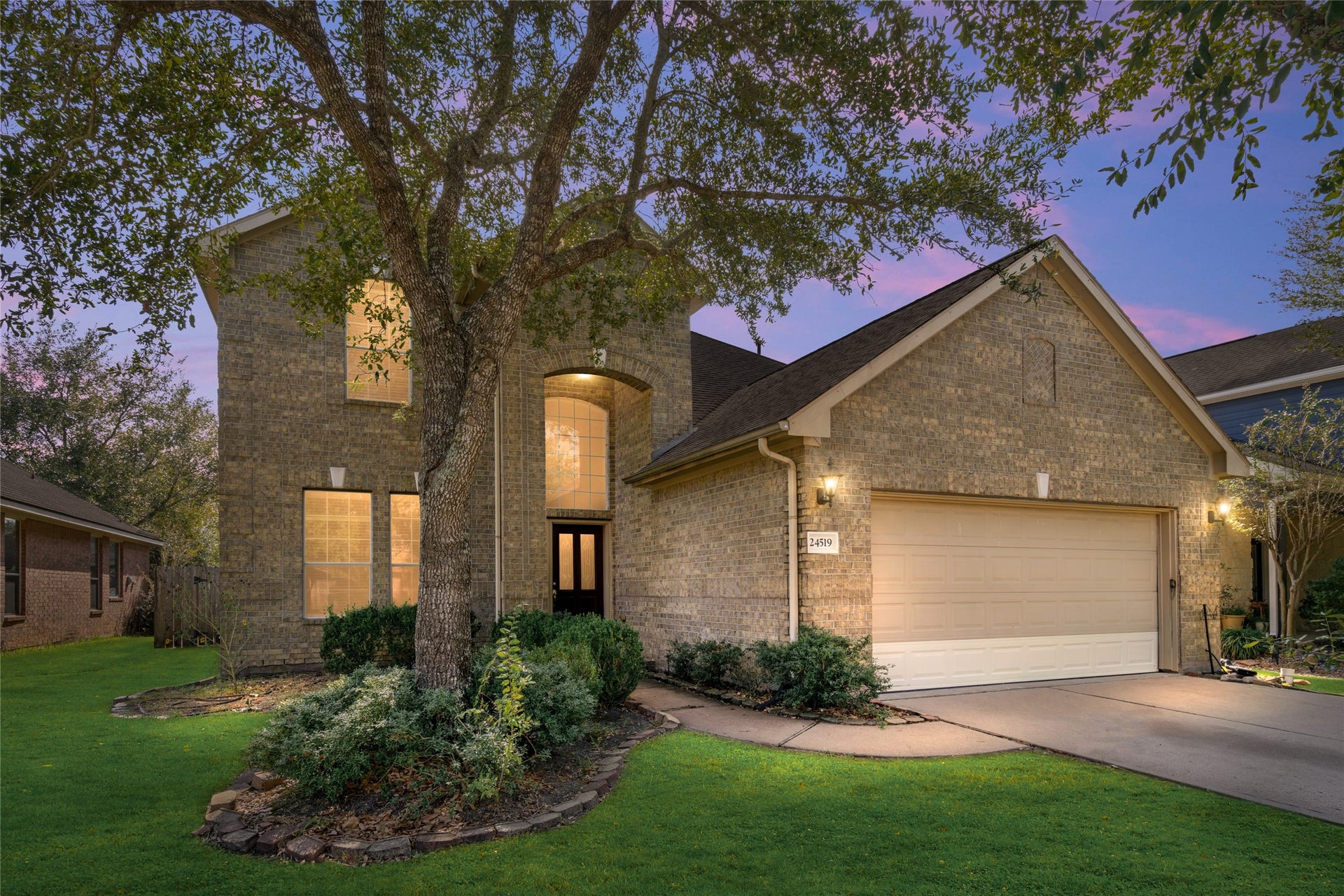 24519 Evangeline Springs Lane, Katy, TX 77494 Charming brick-front home with mature trees, established landscaping, and a welcoming arched entry. The attached two-car garage and attractive curb appeal create a strong first impression.