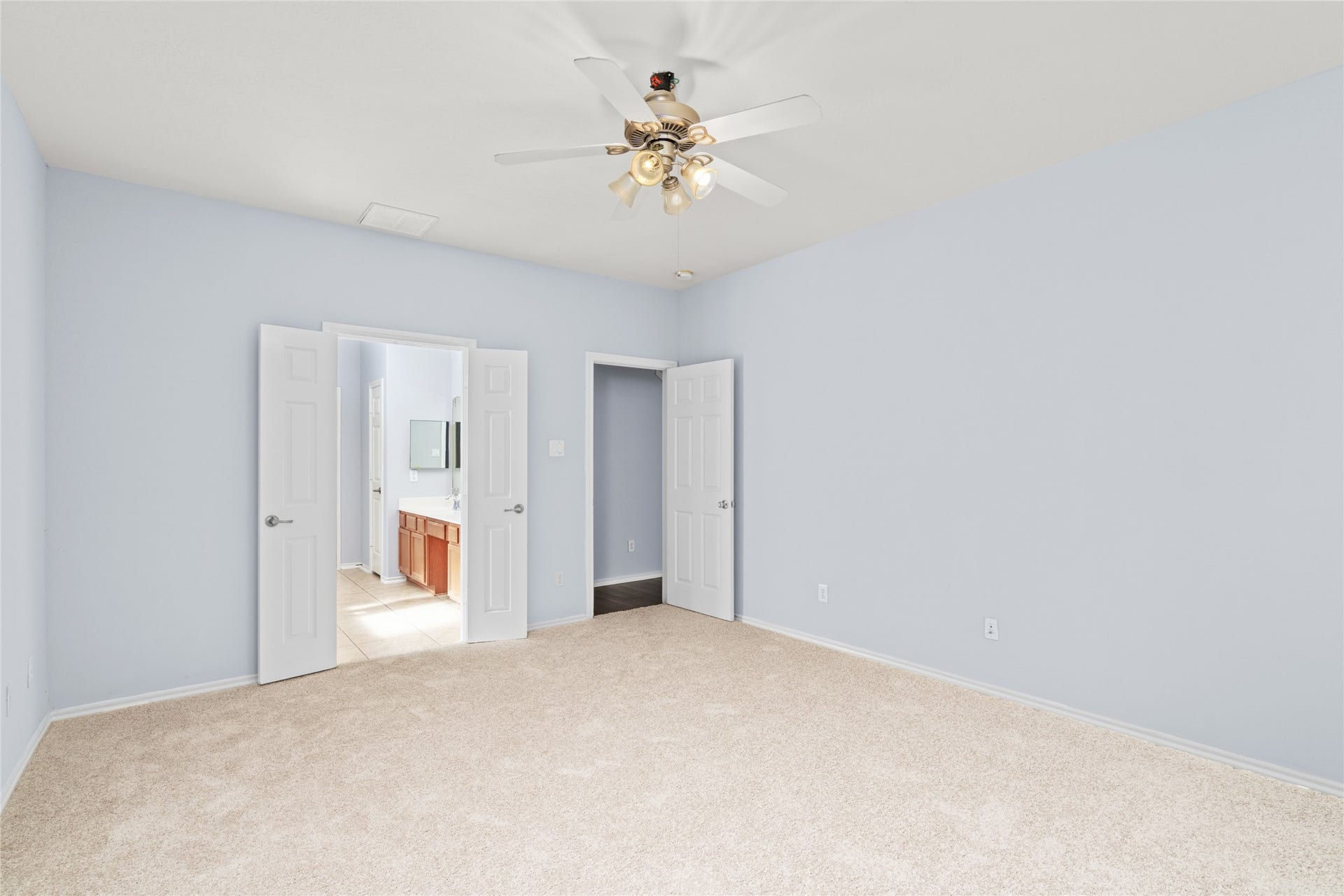 24519 Evangeline Springs Lane, Katy, TX 77494 Alternate view of the primary bedroom highlighting its broad floor area, neutral wall color, soft carpeting, and doorway connections. The uncluttered layout offers flexibility for bedroom furniture and everyday movement.