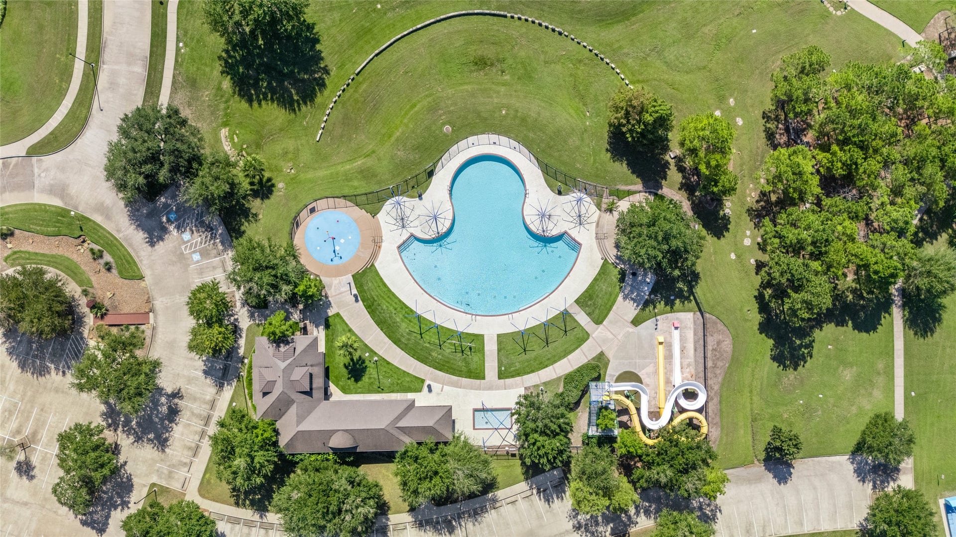 24519 Evangeline Springs Lane, Katy, TX 77494 Aerial view of the community swimming pool and landscaped common areas, showcasing the pool's distinctive shape and surrounding recreation space. The shared amenity provides another option for leisure and outdoor enjoyment close to home.