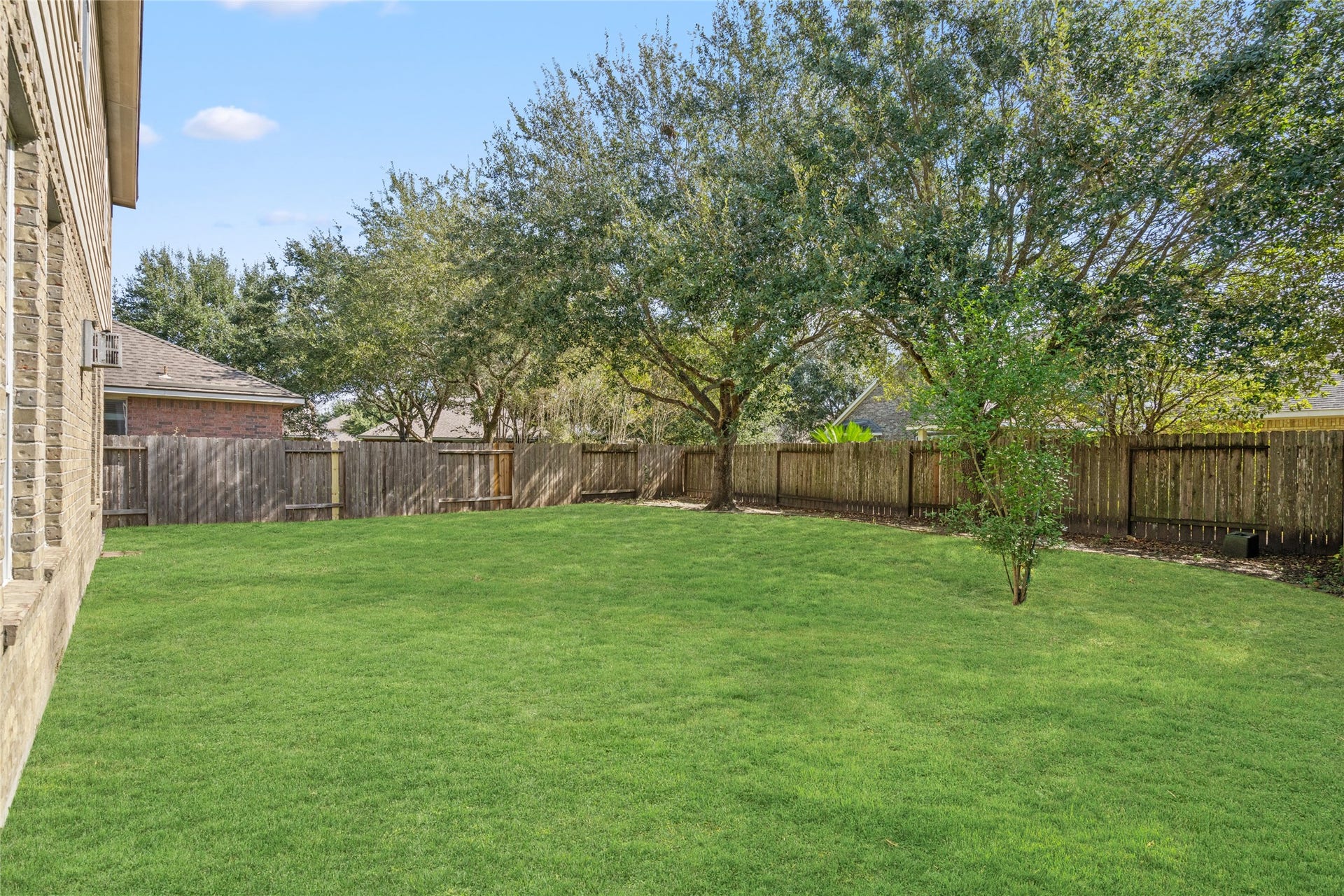 24519 Evangeline Springs Lane, Katy, TX 77494 Spacious fenced backyard with a mature tree and open lawn extending across the rear of the property. The generous open area provides flexibility for outdoor recreation, gardening, or creating a personalized backyard retreat.