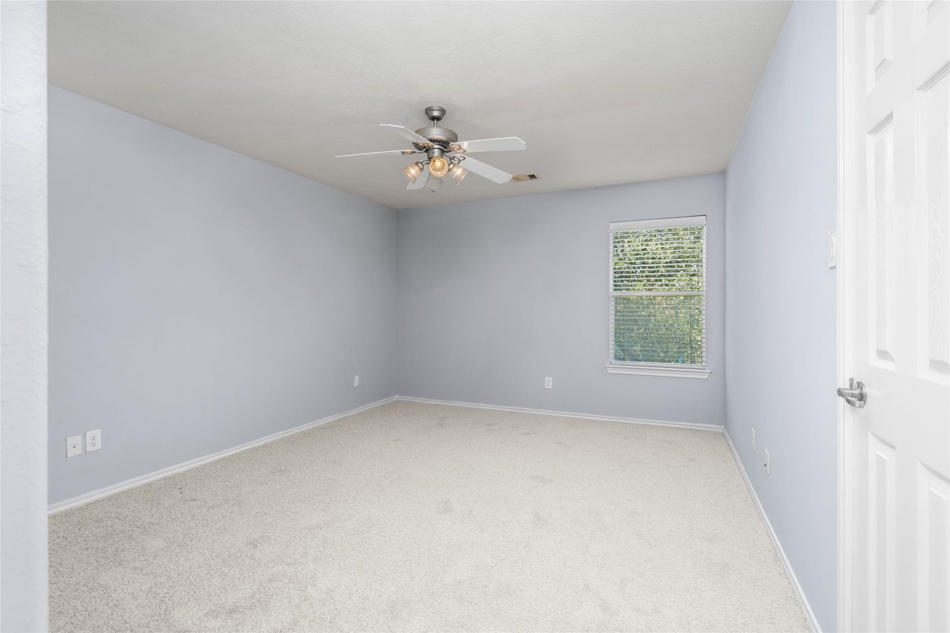24519 Evangeline Springs Lane, Katy, TX 77494 Additional bedroom view featuring soft carpeting, light blue walls, a ceiling fan, and natural light from the window. The straightforward layout offers a versatile space that can be adapted to different furniture arrangements and personal preferences.