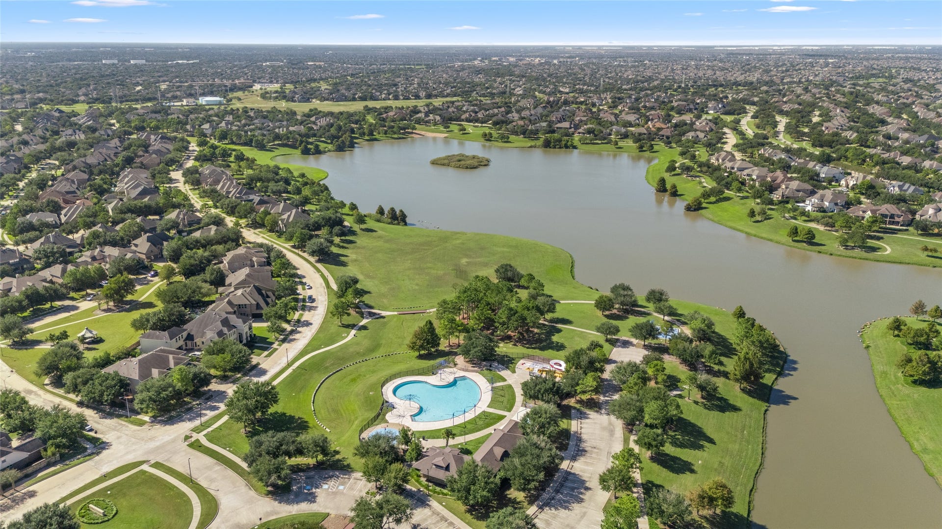 24519 Evangeline Springs Lane, Katy, TX 77494 Aerial view of the surrounding community featuring a lake, green spaces, walking areas, and a neighborhood pool. These shared outdoor amenities offer additional opportunities for recreation and enjoying the surrounding community.