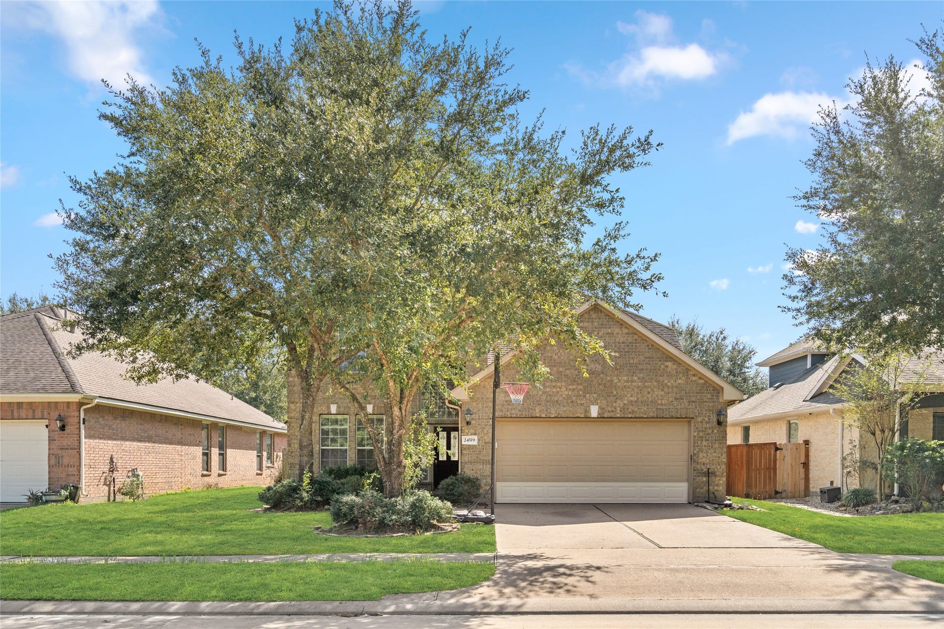 24519 Evangeline Springs Lane, Katy, TX 77494 Inviting front exterior with a two-car garage, mature shade tree, and a well-kept lawn. The established landscaping adds character while creating a pleasant setting for everyday living.