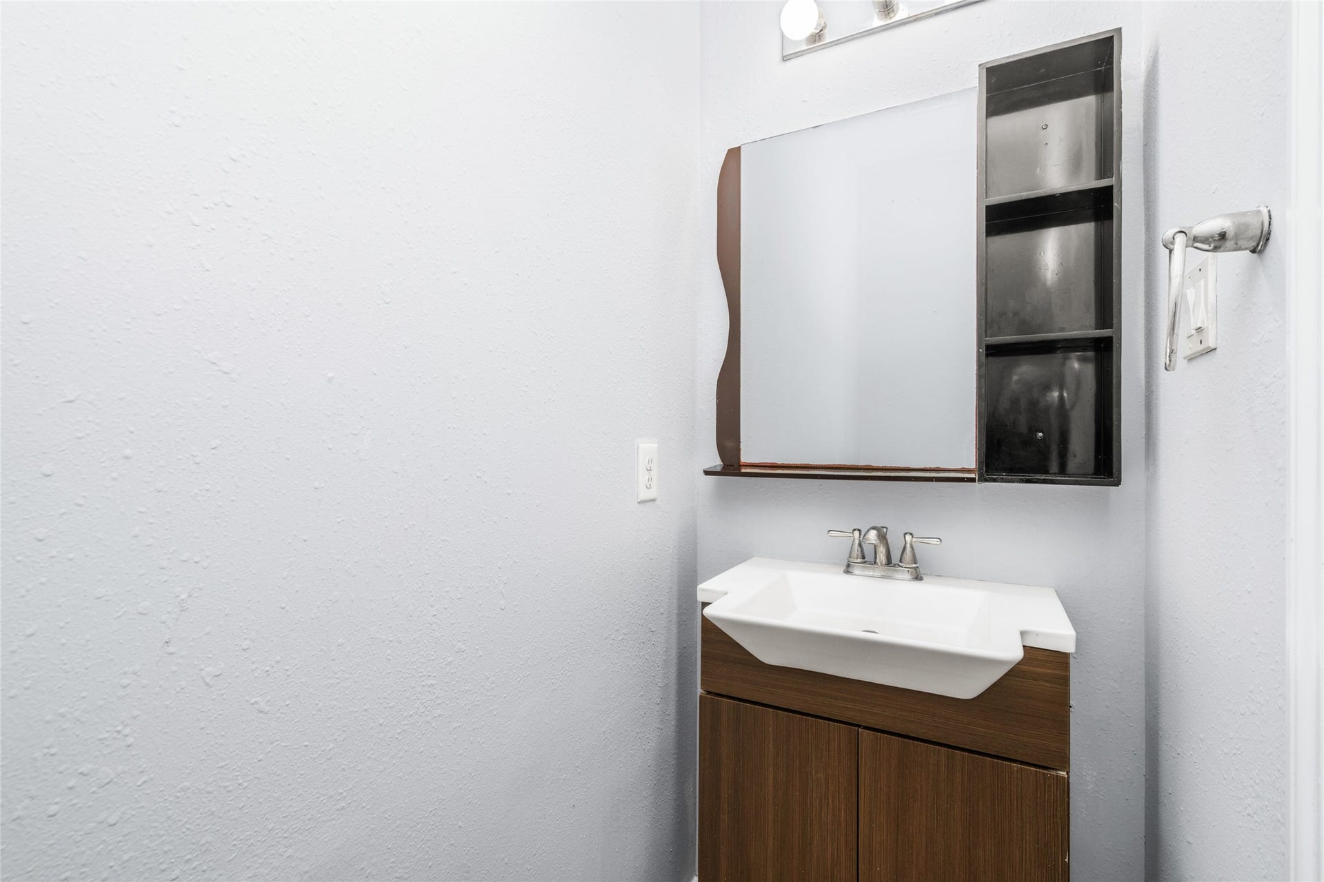 24519 Evangeline Springs Lane, Katy, TX 77494 Convenient first-floor half bathroom featuring a modern vanity, mirror, and neutral finishes. Its location near the main living areas provides practical access for household members and visiting guests.