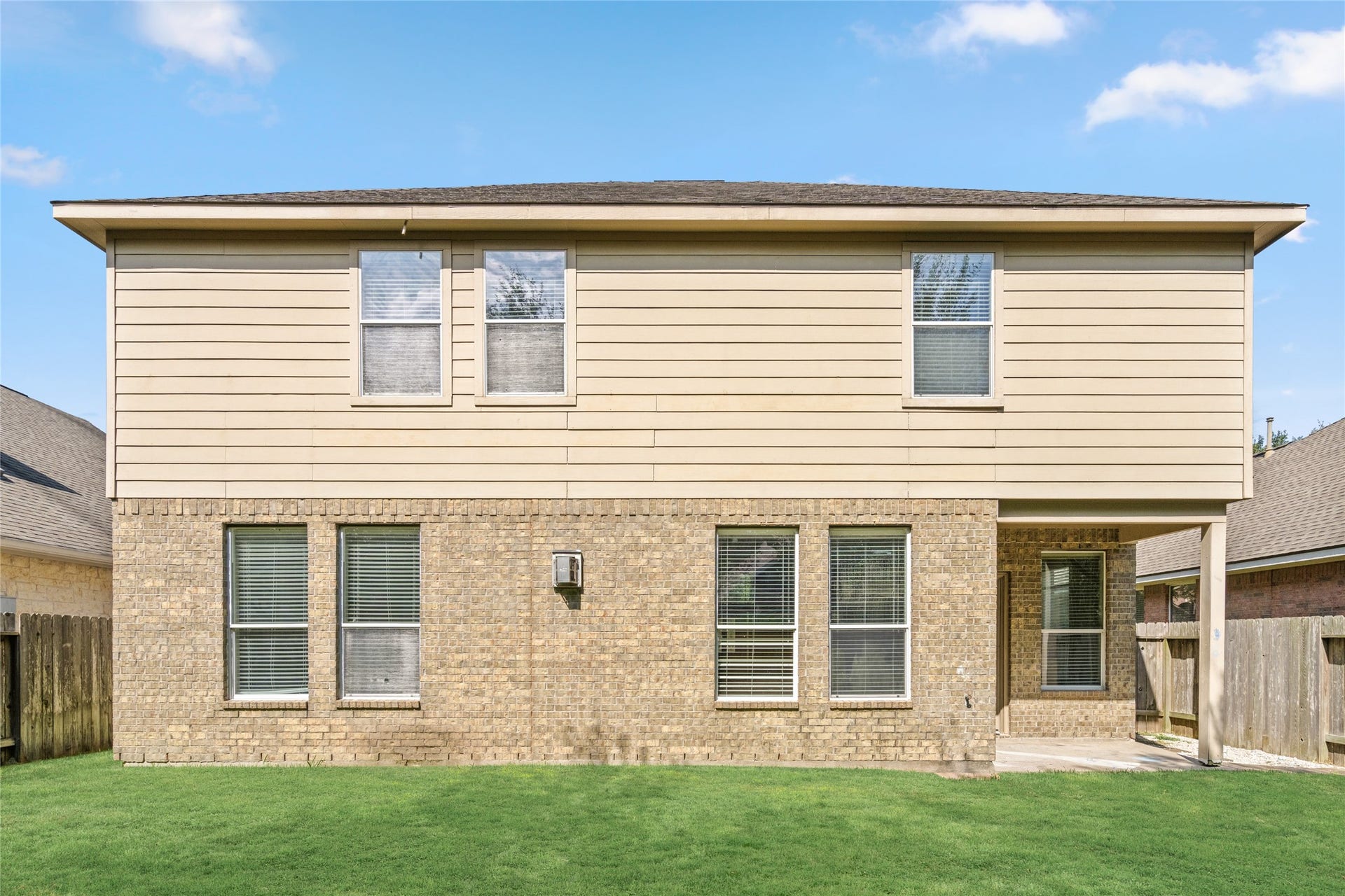24519 Evangeline Springs Lane, Katy, TX 77494 Full rear elevation showcasing the home's two-story design, multiple windows, and access to the backyard. The broad exterior view helps buyers understand the home's layout and how the indoor living spaces relate to the outdoor area.