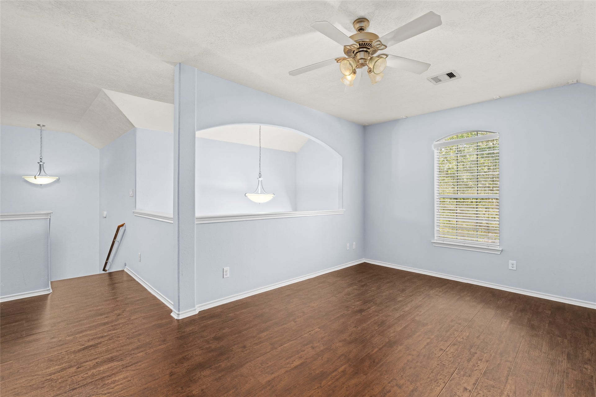 24519 Evangeline Springs Lane, Katy, TX 77494 Open second-floor game room with wood flooring, a ceiling fan, and an expansive layout. The flexible space can serve as a recreation room, hobby area, or additional lounge, giving the household room to enjoy separate activities.