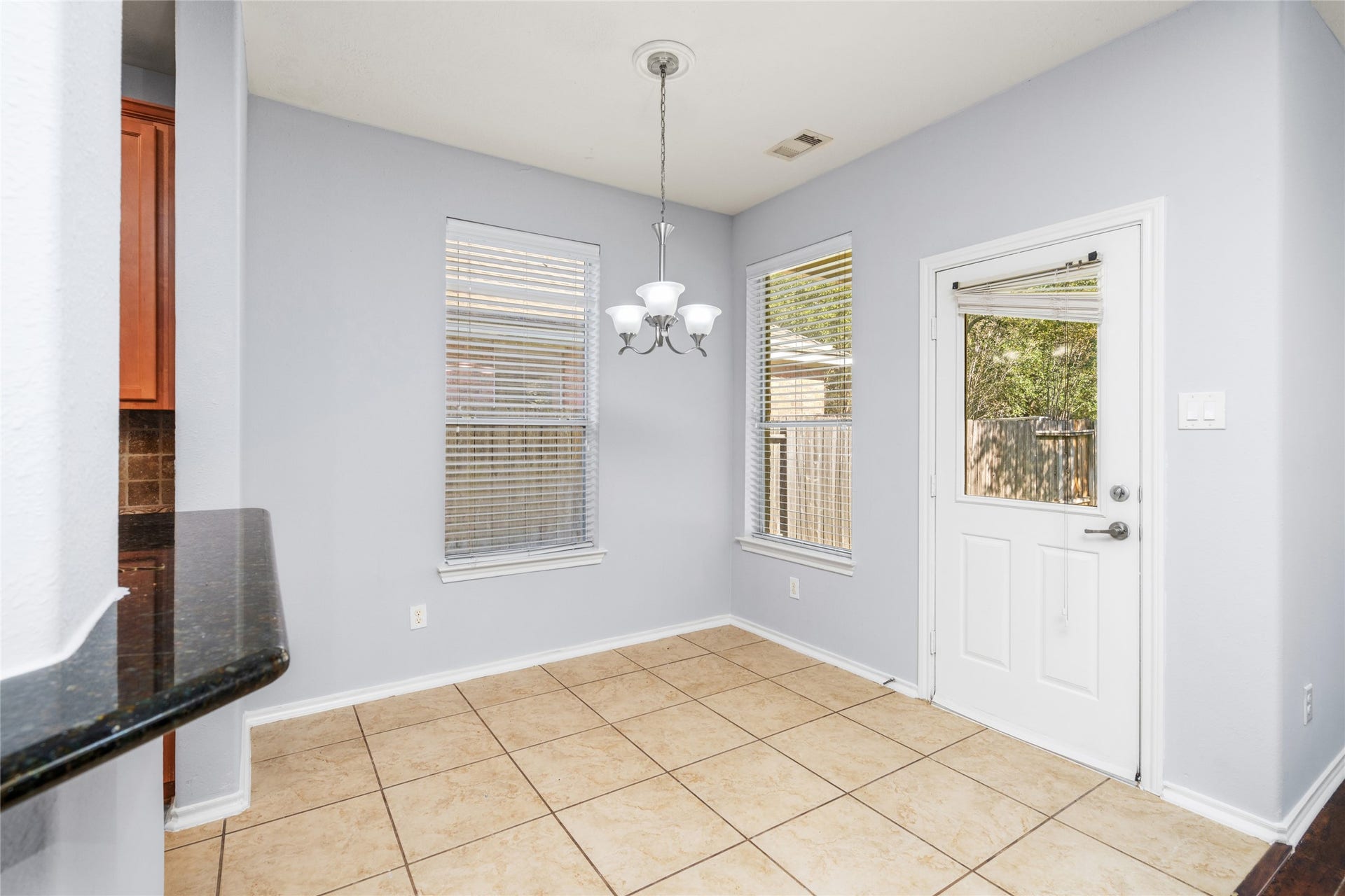 24519 Evangeline Springs Lane, Katy, TX 77494 Bright breakfast area with tiled flooring, windows, and an exterior door overlooking the outdoor space. Its placement beside the kitchen makes daily dining convenient and provides a natural connection to the backyard.
