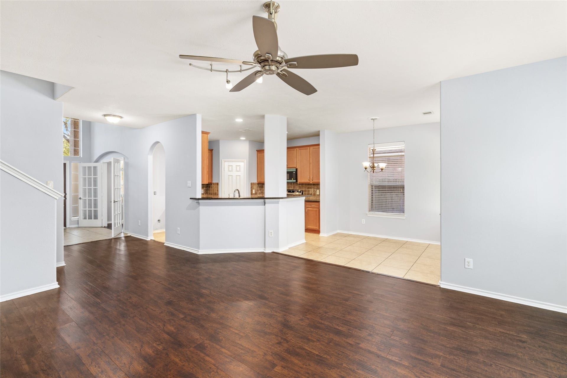 24519 Evangeline Springs Lane, Katy, TX 77494 Wide view of the open living and dining areas, showcasing the continuous wood flooring and direct connection to the kitchen. The open sightlines make it easier to stay connected with family or guests while preparing meals or relaxing.