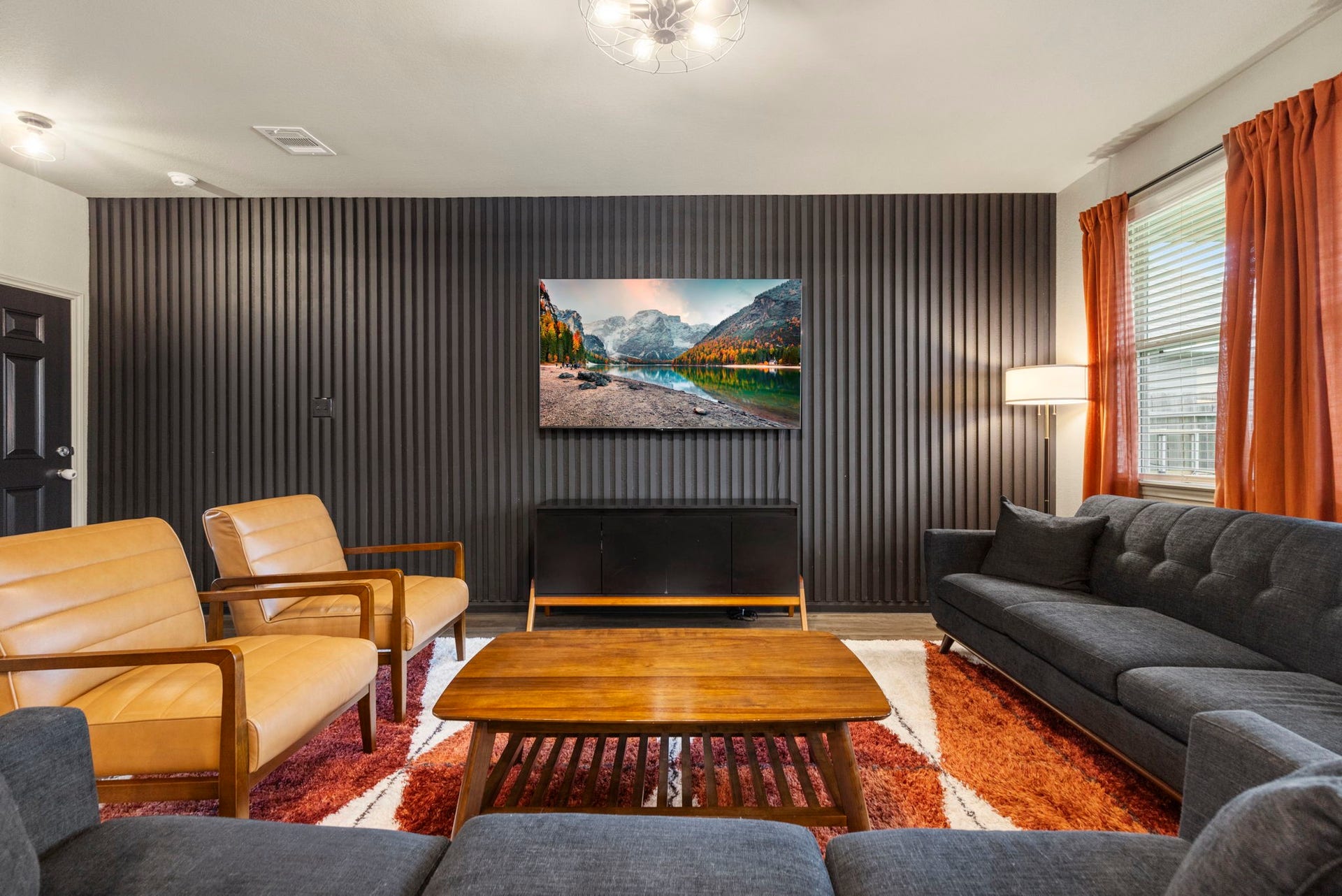 The inviting living room offers a stylish accent wall and comfortable space for relaxing and entertaining.