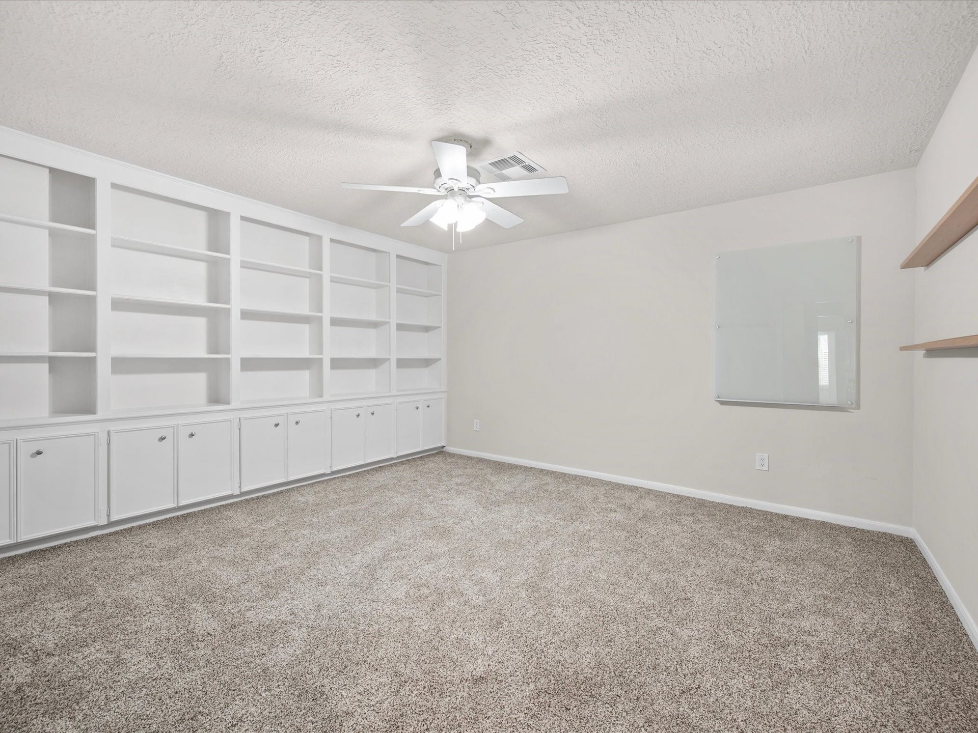 15902 Cumbria Drive, Spring, TX 77379 A wall of white built-in shelving and cabinets in this upstairs room. Books, games, or a library.