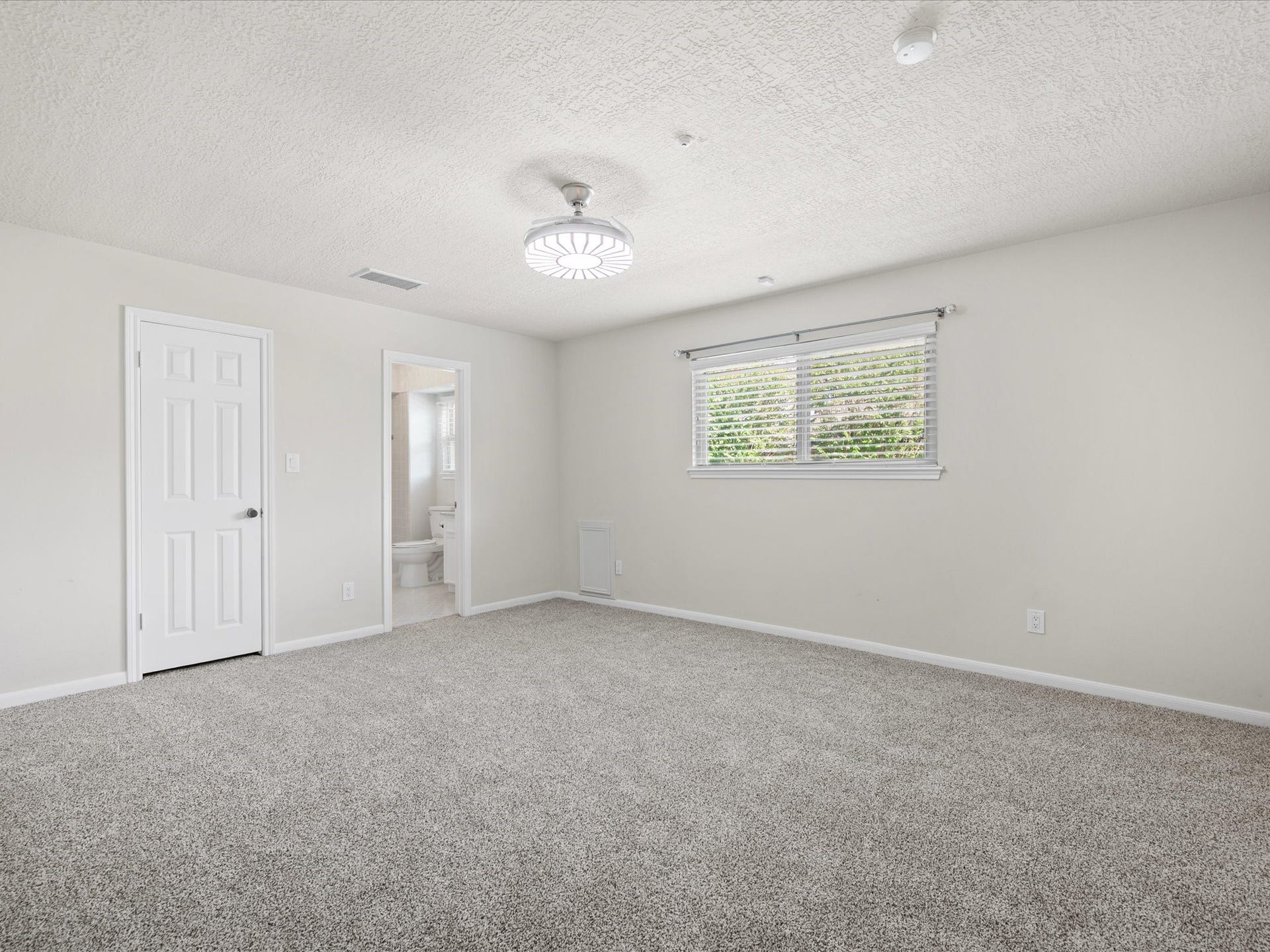 15902 Cumbria Drive, Spring, TX 77379 One of the upstairs bedrooms. Carpet, a ceiling fan, and a window over the yard.