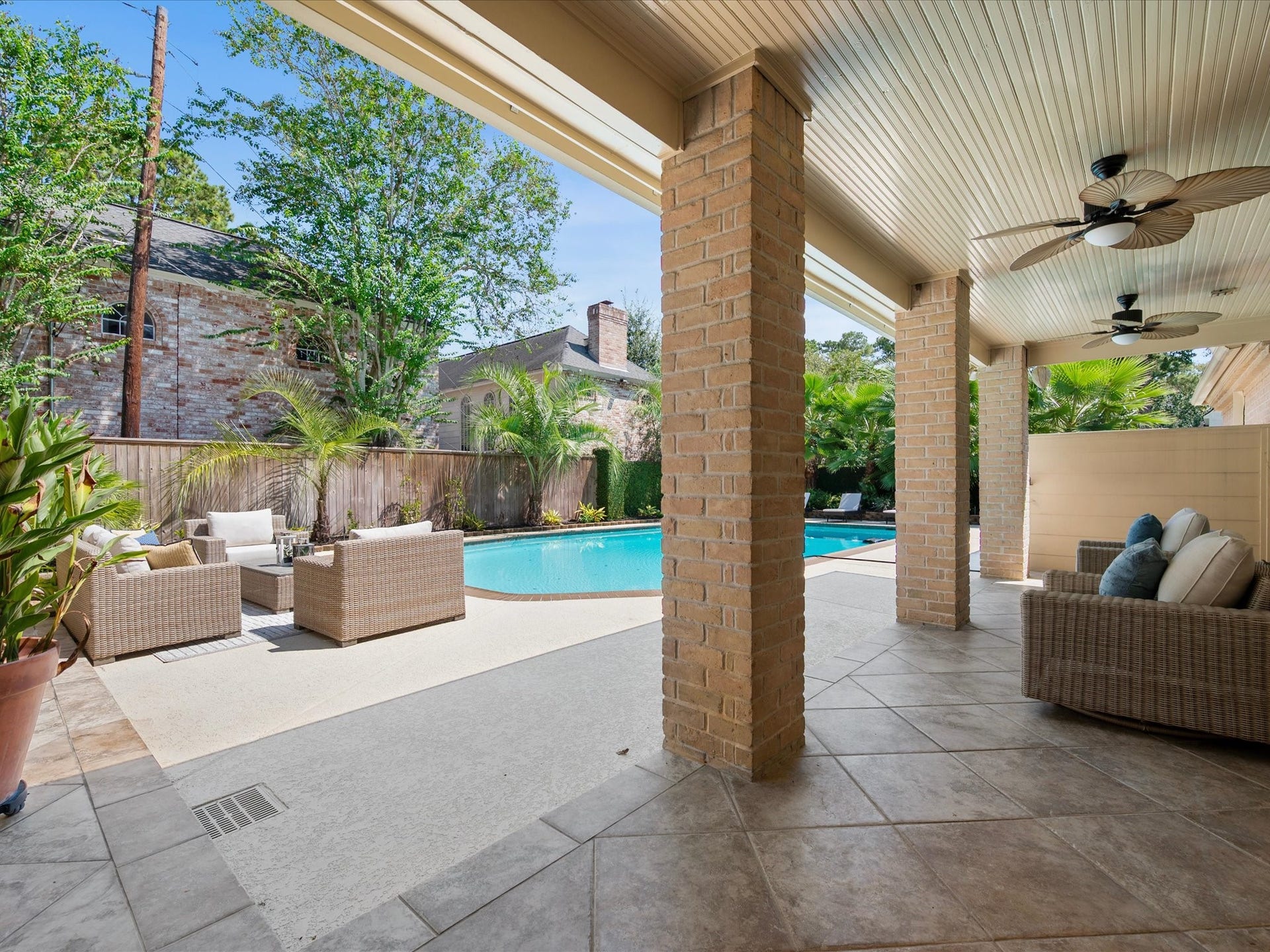 15902 Cumbria Drive, Spring, TX 77379 Under the covered patio, looking out at the pool and lounge area. Two ceiling fans overhead.