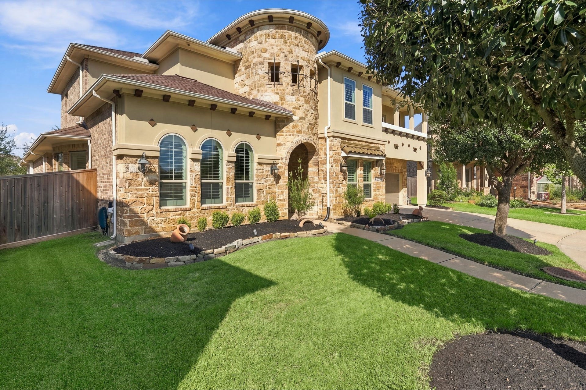 13714 Arcott Bend Drive, Tomball, TX 77377 WOW FACTOR curb appeal! A stunning stone turret, grand arched entry, beautiful architectural details, and lush, manicured landscaping create an unforgettable first impression. This elegant luxury home in gated Wildwood at Northpointe offers timeless sophistication and exceptional pride of ownership!