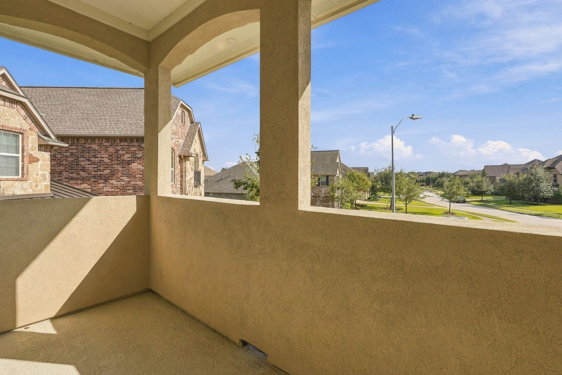 13714 Arcott Bend Drive, Tomball, TX 77377 Charming second-story covered balcony featuring elegant arched architectural details and elevated views of the beautifully maintained Wildwood at Northpointe neighborhood. A wonderful outdoor retreat to enjoy fresh air and peaceful neighborhood views.