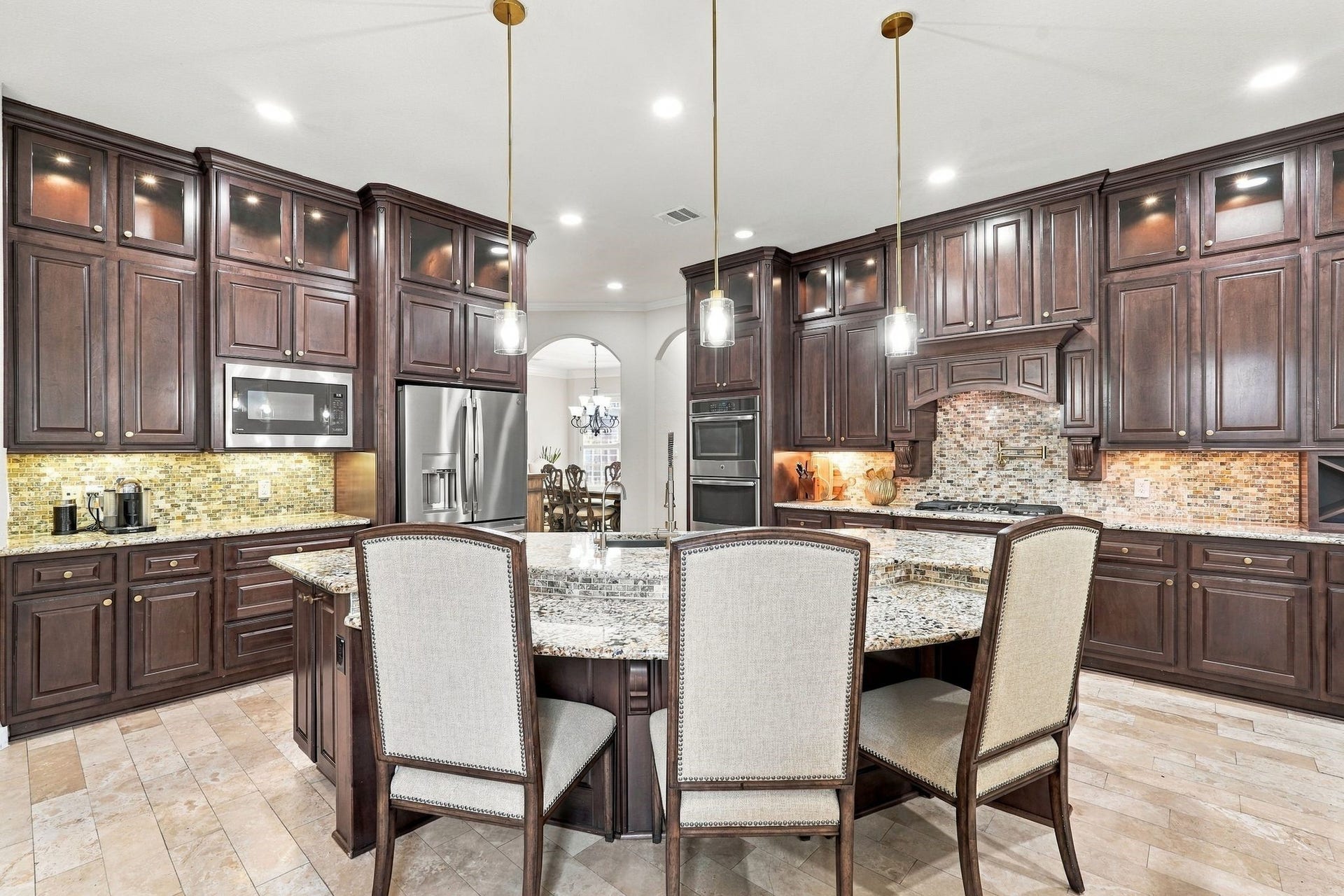 13714 Arcott Bend Drive, Tomball, TX 77377 The showstopping centerpiece of this gourmet kitchen is the expansive granite island, featuring a beautiful multi-level design, generous breakfast bar seating, and an integrated sink. Elegant pendant lighting highlights this impressive space, perfect for meal preparation, casual dining, and effortless entertaining.
