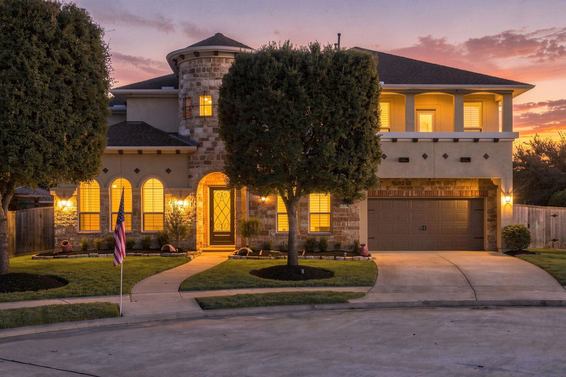 13714 Arcott Bend Drive, Tomball, TX 77377 Stunning twilight exterior of this luxury two-story home in gated Wildwood at Northpointe, featuring beautiful stone and stucco architecture, arched windows, elegant exterior lighting, and manicured landscaping. Zoned to Tomball ISD!