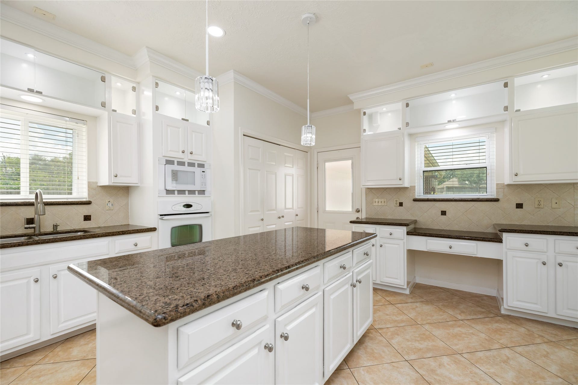 9718 Deverell Drive, Sugar Land, TX 77498 Glass-front cabinets showcase dishware above the cooktop.