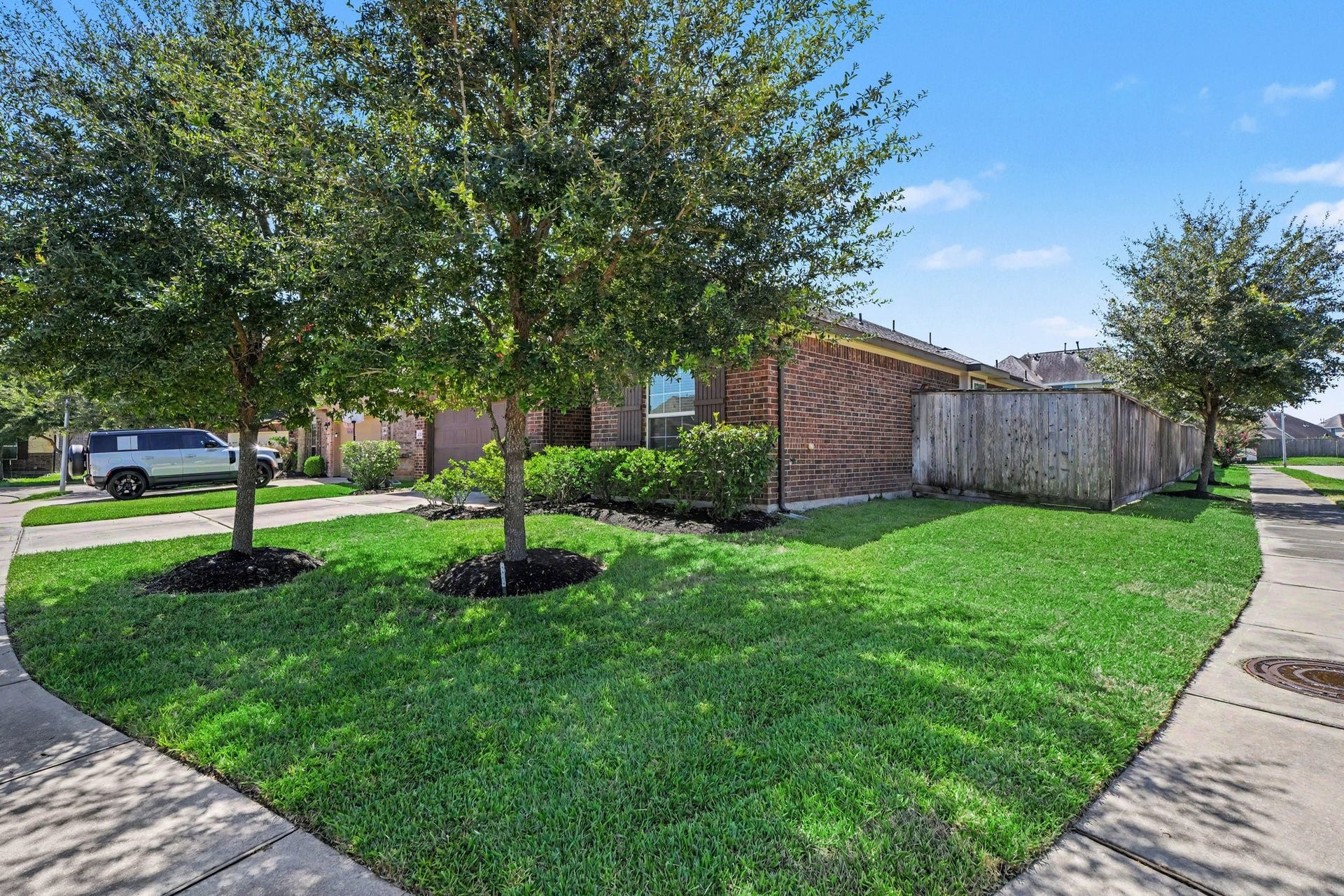Corner lot with newly installed sod and mulch in the front yard