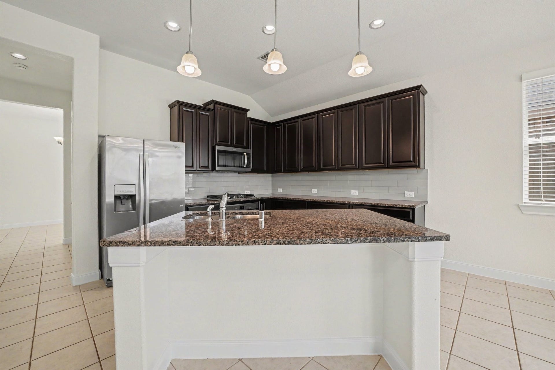 View of the kitchen island, with access to the formal dining room, pantry and a doorway leading to the oversize laundry room