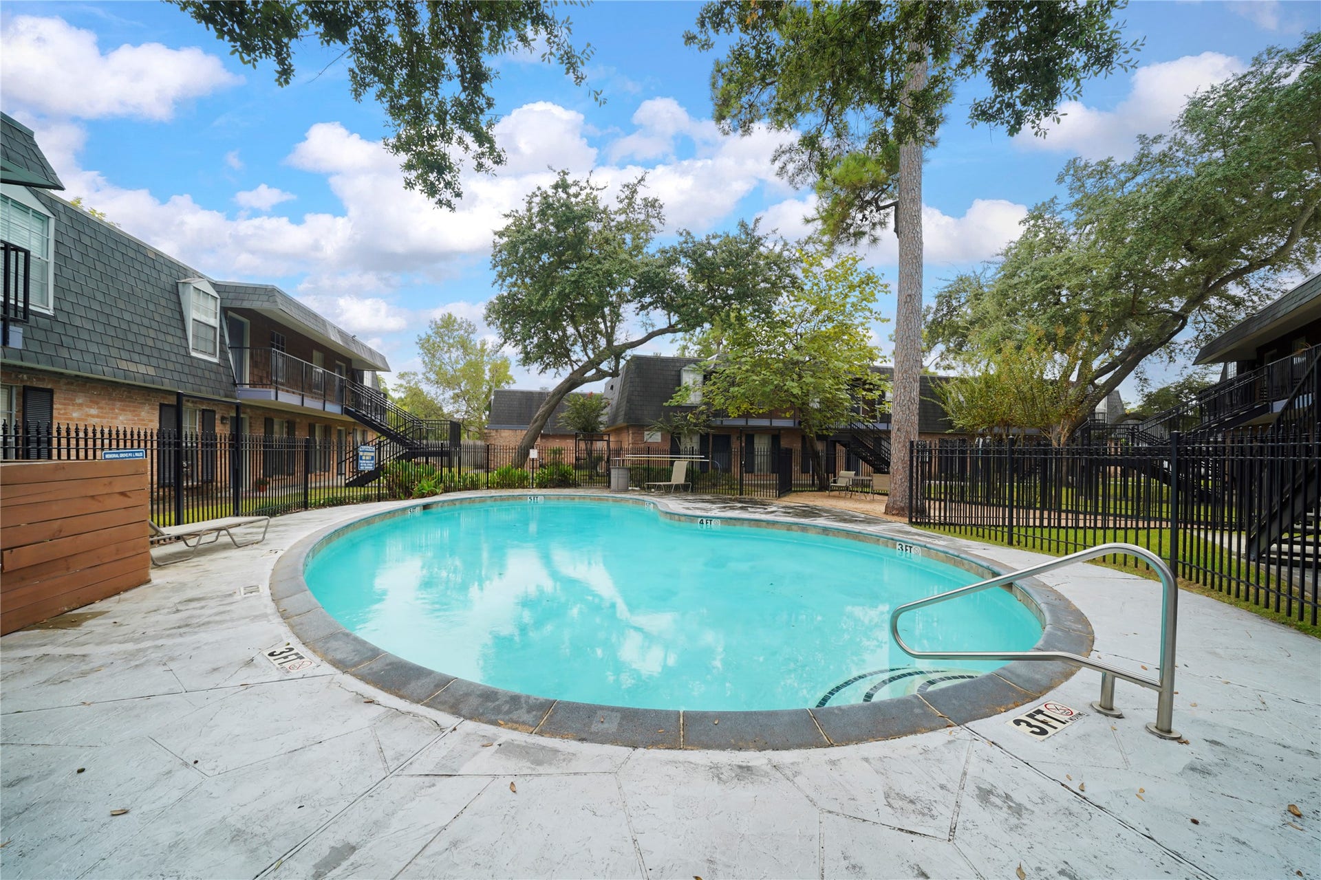 Sparkling community swimming pool featuring a spacious concrete sun deck and lounge area for relaxation.