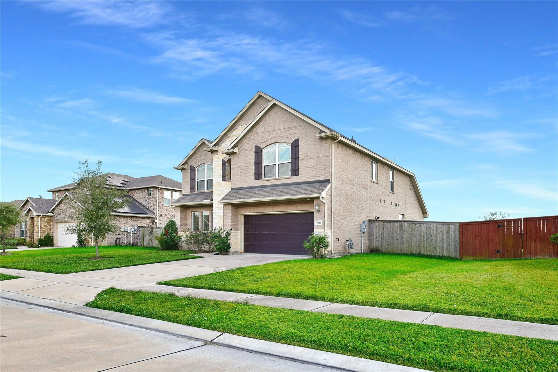 5936 Pearland Place, Pearland, TX 77581 This is a modern two-story brick home with a spacious garage and well-maintained lawn, situated on a quiet street. It features a fenced backyard, providing privacy and a safe space for outdoor activities.