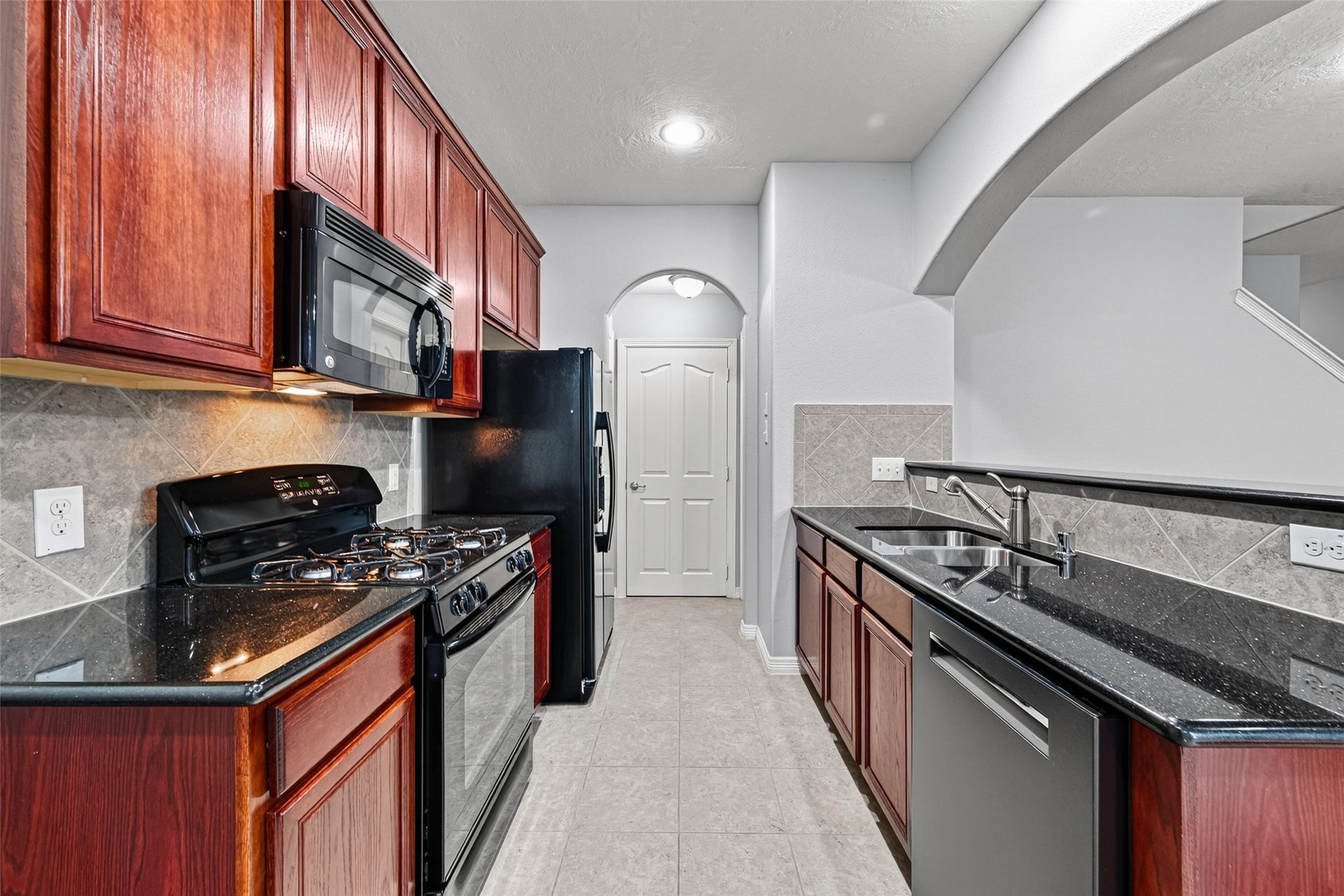 8910 Minola Oaks Drive, Houston, TX 77064 There are three doors at the end of the kitchen: pantry, garage, half bath.