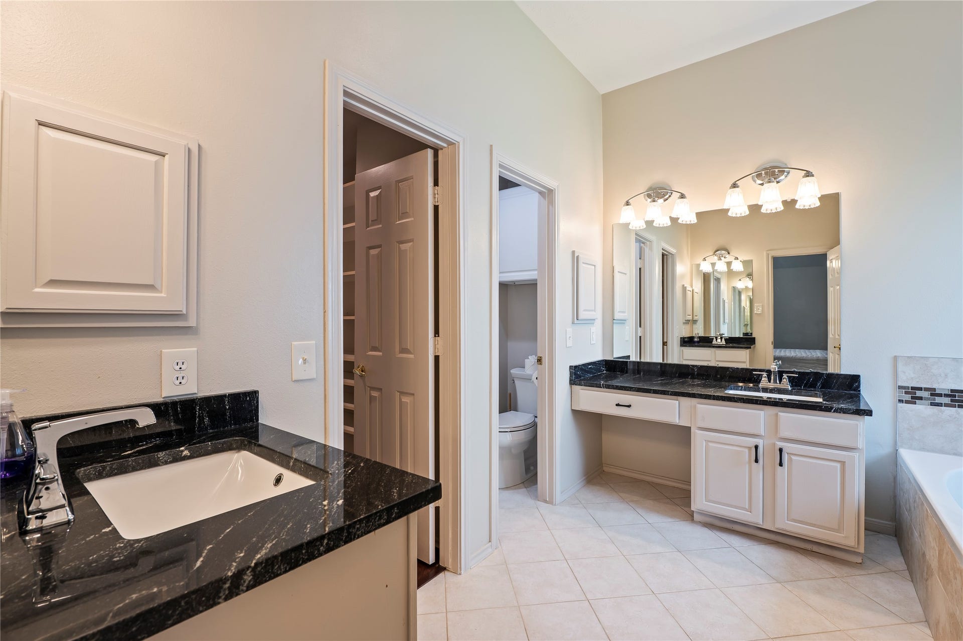 2009 Stapleton Drive, Friendswood, TX 77546 Beautiful primary bath with tile flooring, dual vanities, and granite counter tops.