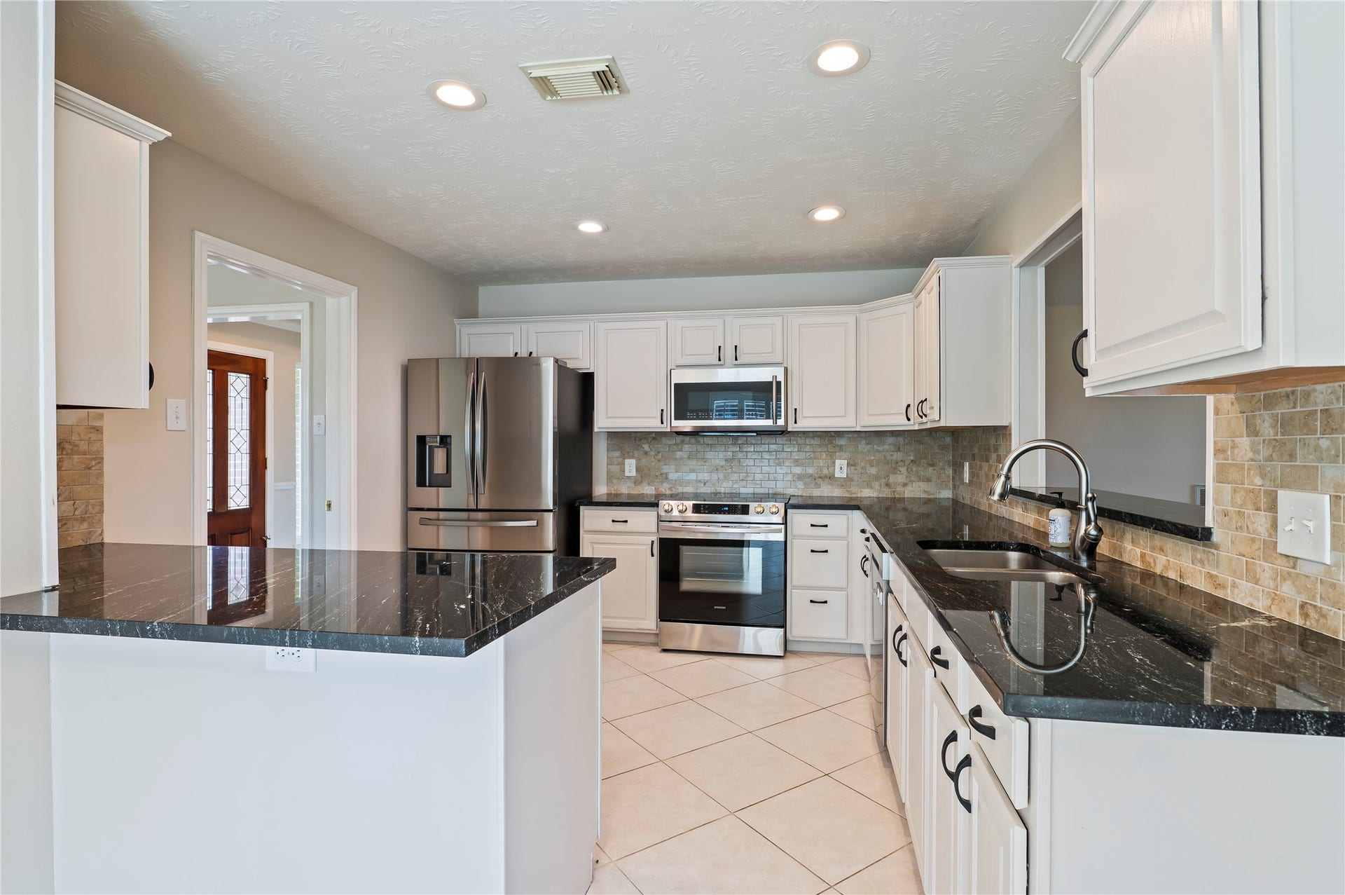 2009 Stapleton Drive, Friendswood, TX 77546 Beautiful kitchen with tile flooring, dark granite counter tops, and tons of wood cabinet storage.