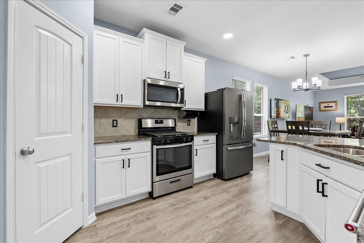 28619 Riverside Crest Lane, Huffman, TX 77336 Bright kitchen features granite countertops, crisp cabinetry, stainless appliances and plenty of workspace.