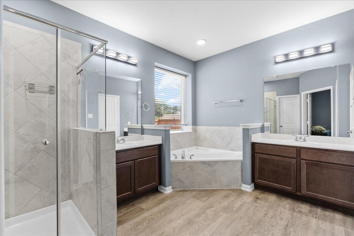28619 Riverside Crest Lane, Huffman, TX 77336 Spacious primary bath features dual vanities, a soaking tub and separate shower for a relaxing start or end to your day.