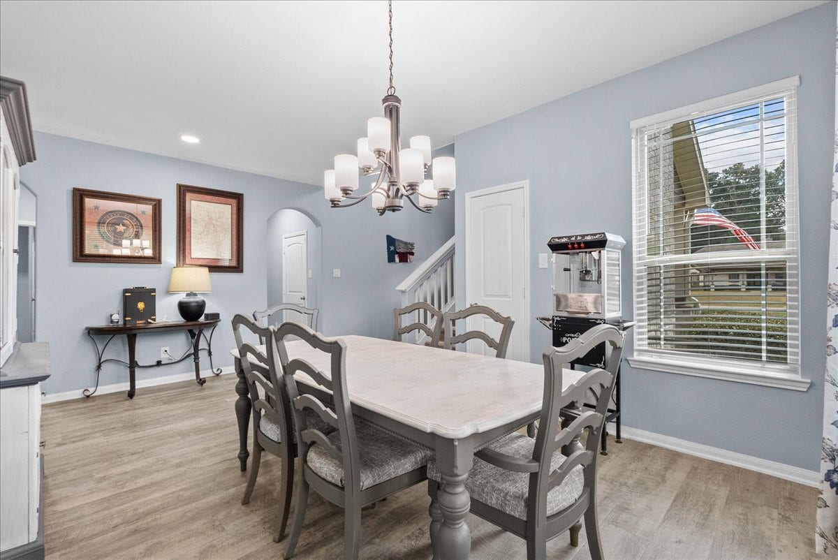 28619 Riverside Crest Lane, Huffman, TX 77336 Large windows fill the dining area with natural light while vinyl plank flooring keeps the space fresh and inviting.