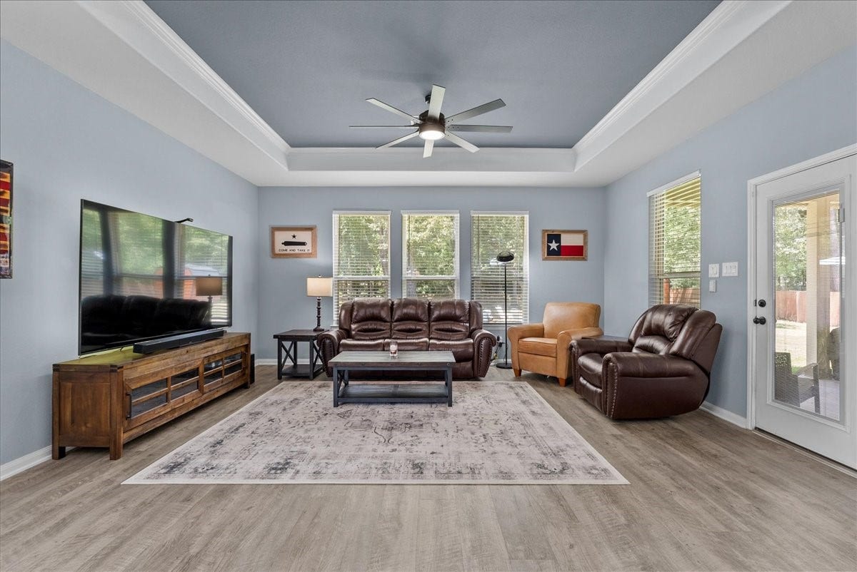 28619 Riverside Crest Lane, Huffman, TX 77336 Relax and unwind in the inviting family room featuring a beautiful tray ceiling and abundant natural light.