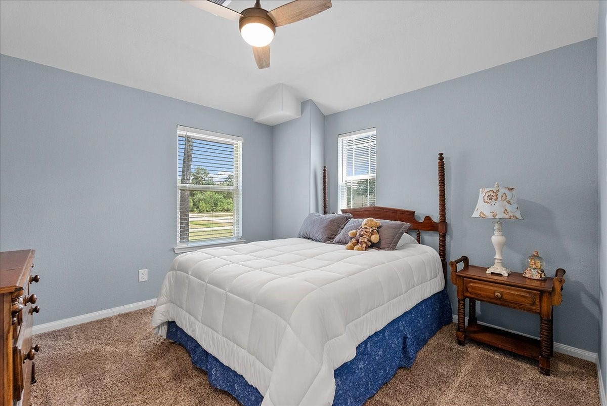 28619 Riverside Crest Lane, Huffman, TX 77336 Bright secondary bedroom offers comfortable carpet, a ceiling fan and plenty of natural light.